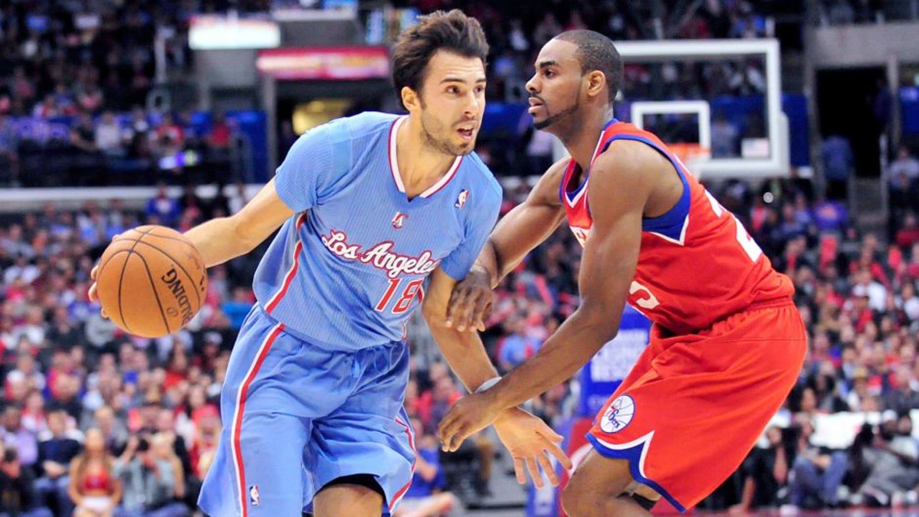 February 9, 2014; Los Angeles, CA, USA; Los Angeles Clippers shooting guard Sasha Vujacic (18) moves the ball against Philadelphia 76ers shooting guard Elliot Williams (25) during the second half at Staples Center. Mandatory Credit: Gary A. Vasquez-USA TODAY Sports