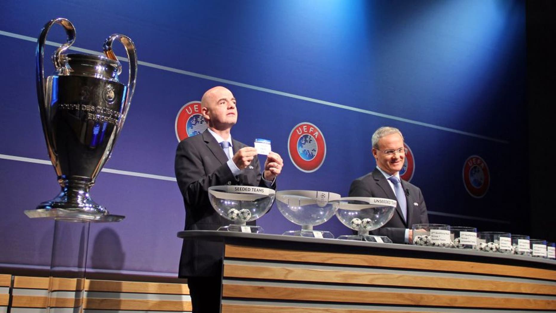 NYON, SWITZERLAND - JUNE 22: UEFA General Secretary Gianni Infantino (L) shows the lot of Lincoln Red Imps FC next to UEFA director of competitions Giorgio Marchetti (R) during the draw of the first two qualifying rounds of the UEFA Champions League 2015/16 at the UEFA Headquarters in Nyon, Switzerland on June 22, 2015. (Photo by Fatih Erel/Anadolu Agency/Getty Images)