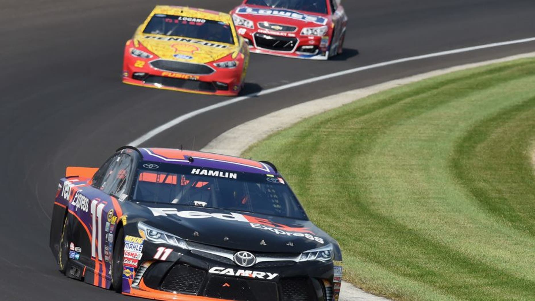 INDIANAPOLIS, IN - JULY 24: Denny Hamlin, driver of the #11 FedEx Express Toyota, leads Joey Logano, driver of the #22 Shell Pennzoil Ford, and Jimmie Johnson, driver of the #48 Lowe's Red Vest Chevrolet, during the NASCAR Sprint Cup Series Crown Royal Presents the Combat Wounded Coalition 400 at Indianapolis Motor Speedway on July 24, 2016 in Indianapolis, Indiana. (Photo by Bobby Ellis/Getty Images)