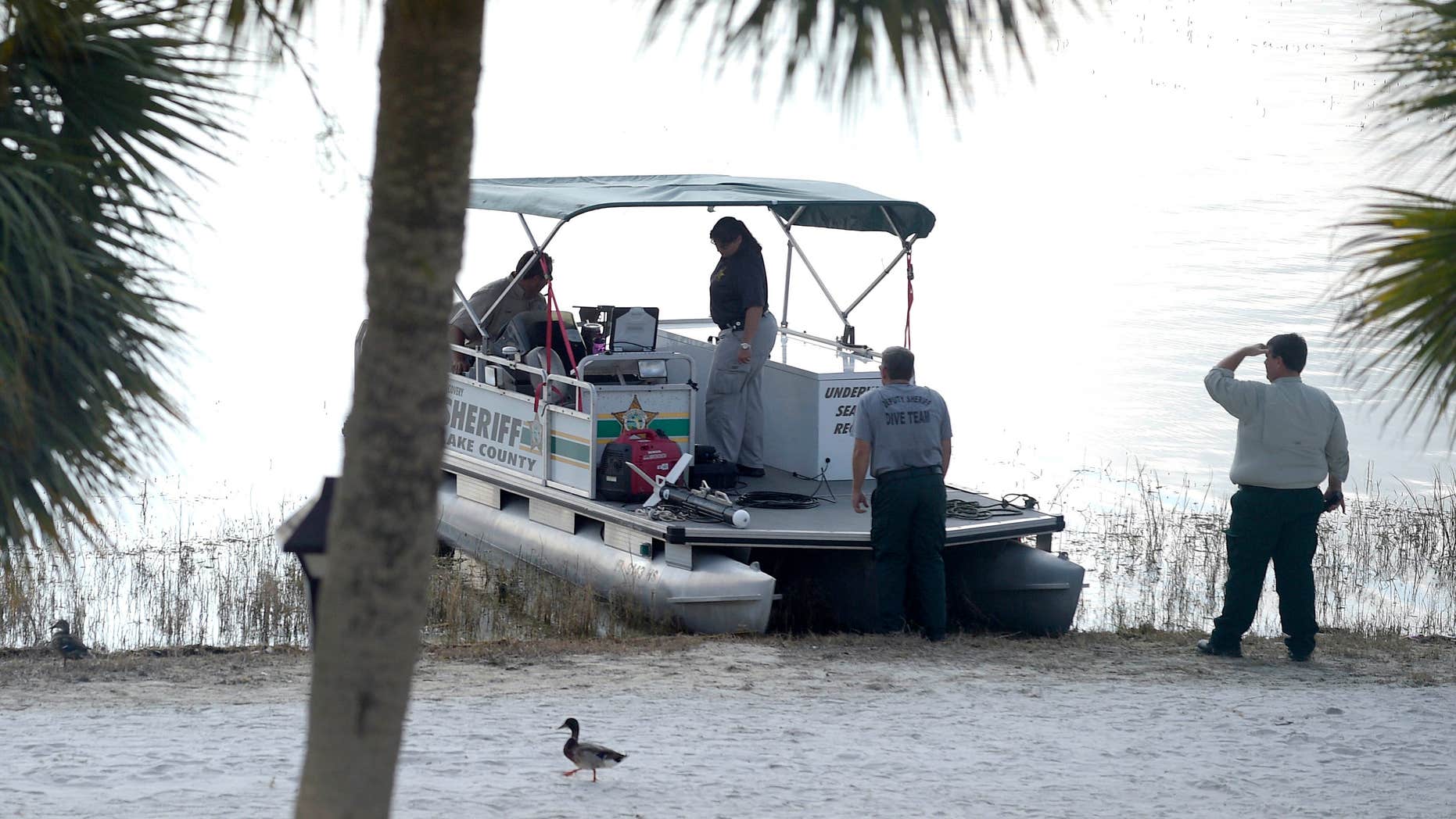 FILE- In this June 15, 2016 file photo, law enforcement officials search the Seven Seas Lagoon outside the Grand Floridian Resort & Spa in Lake Buena Vista, Fla., after Lane Graves, a two-year-old toddler, was dragged into the lake by an alligator.