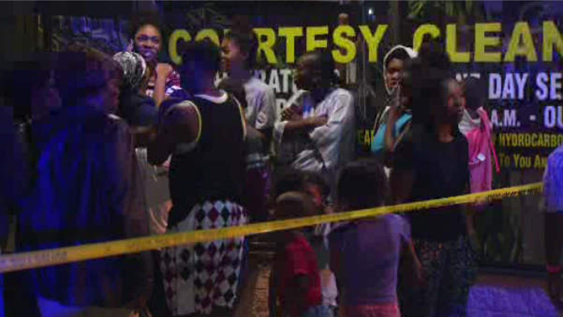 Aug. 7, 2015: In this image made from a video provided by KNBC-TV, relatives of a suspected attacker arrive at the scene after a fatal police shooting in Long Beach, Calif.