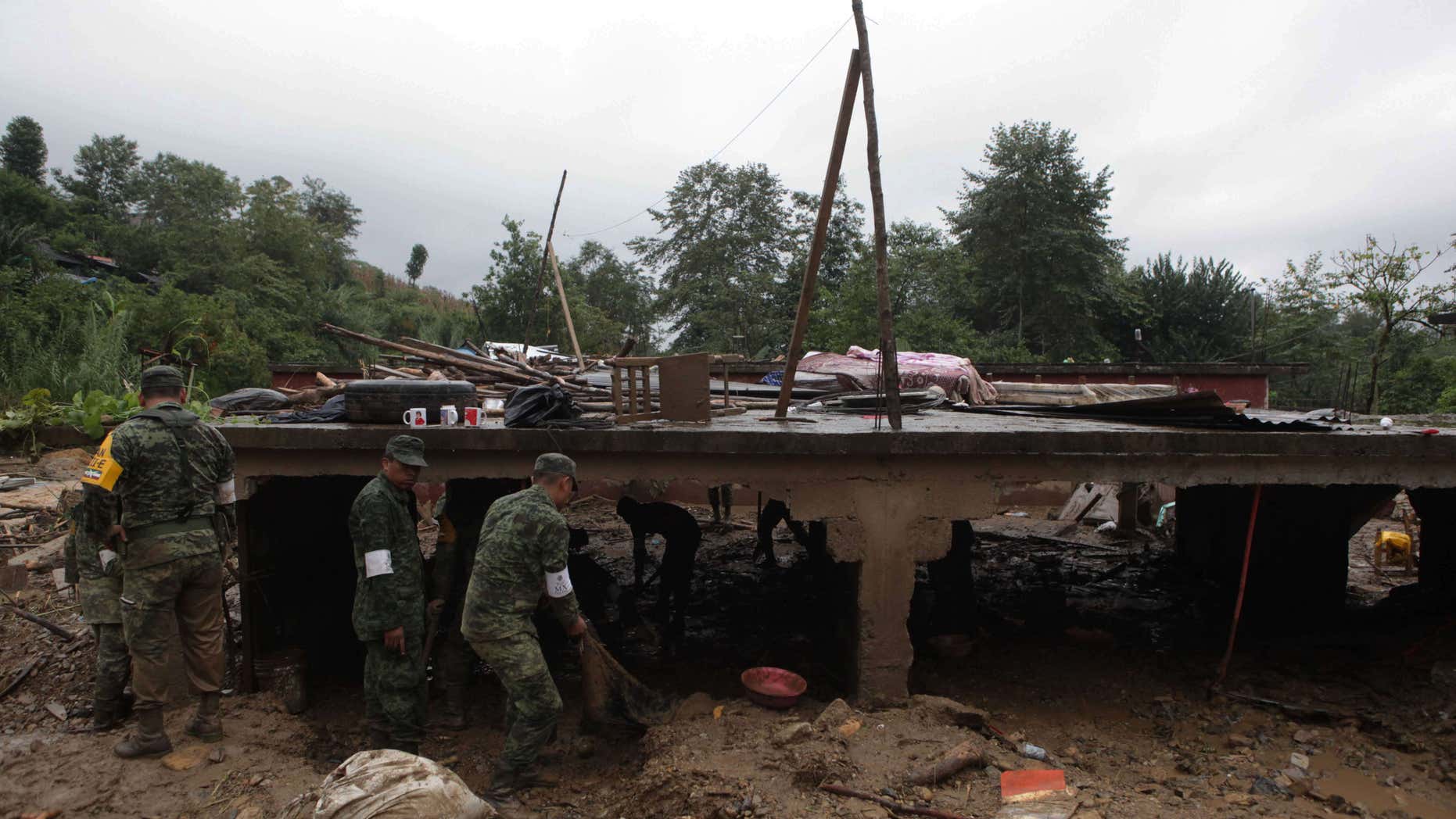 Aug. 7, 2016: Mexican soldiers remove debris from the remains of a house flattend by a mudslide in Xaltepec, on the mountainous north of Puebla state, Mexico.