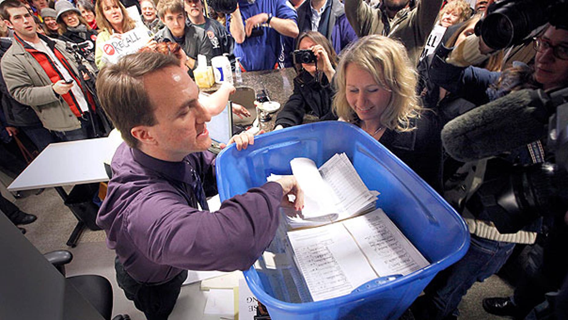 In this April 1, 2011 file photo, David Buerger, an elections specialist with the Wisconsin Government Accountability Board, inspects recall petitions filed against Sen. Dan Kapanke, R-LaCrosse, in his Madison, Wis. office.