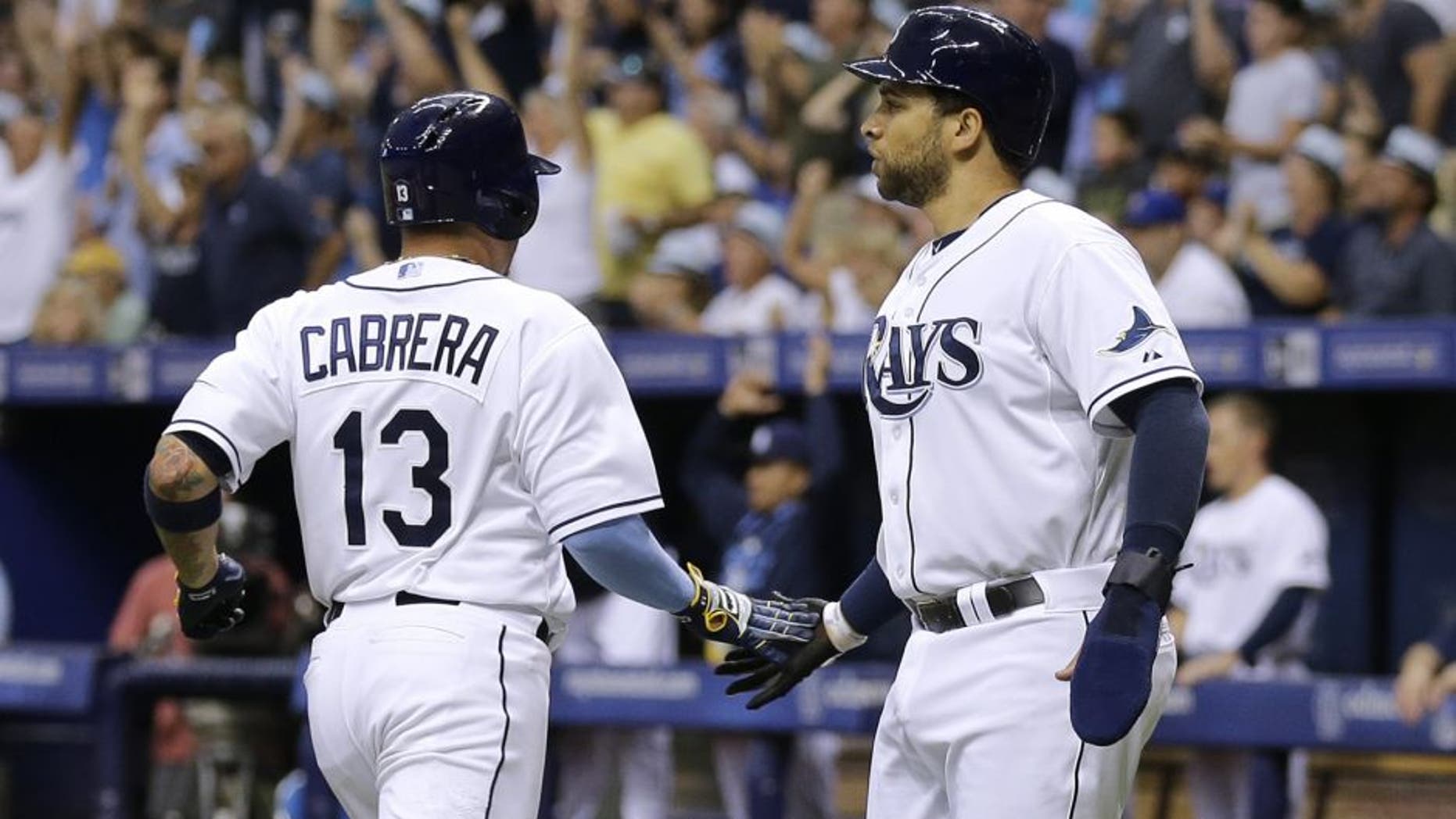 Tampa Bay Rays' James Loney and Asdrubal Cabrera (13) celebrate after scoring on a two-run single by Kevin Kiermaier off New York Mets starting pitcher Noah Syndergaard during the first inning of an interleague baseball game Saturday, Aug. 8, 2015, in St. Petersburg, Fla. (AP Photo/Chris O'Meara)