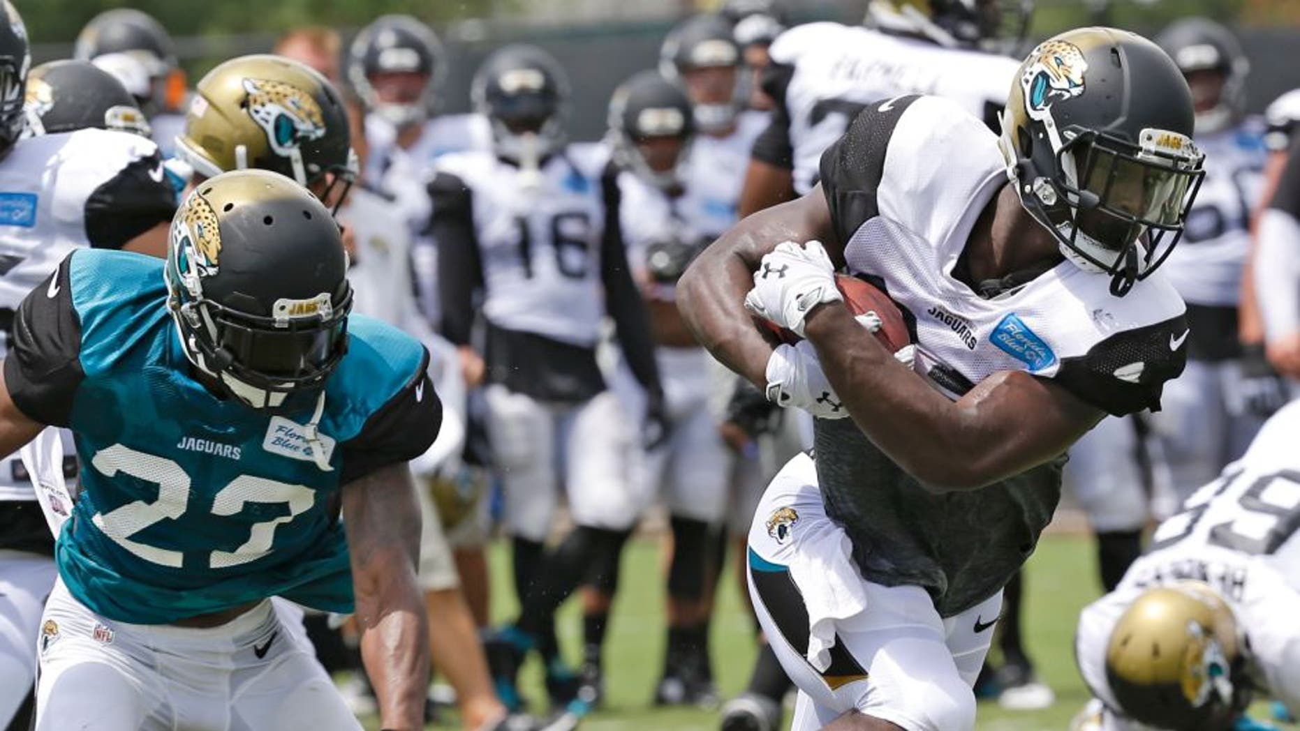 Jacksonville Jaguars running back T.J. Yeldon, front right, gets past cornerback Jeremy Harris (23) during practice at NFL football training camp, Wednesday, Aug. 5, 2015, in Jacksonville, Fla. (AP Photo/John Raoux)