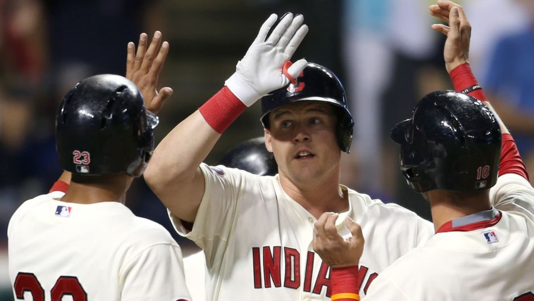 Cleveland Indians' Jerry Sands, center, is congratulated from teammates Michael Brantley, left, and Yan Gomes after hitting a grand slam off Minnesota Twins relief pitcher Blaine Boyer during the fifth inning of a baseball game, Saturday, Aug. 8, 2015, in Cleveland.
