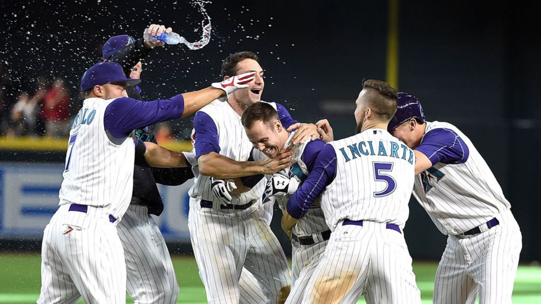 PHOENIX, AZ - AUGUST 09: Chris Owings #16 of the Arizona Diamondbacks celebrates with teammates after hitting a walk off single in the tenth inning against the Cincinnati Reds at Chase Field on August 9, 2015 in Phoenix, Arizona. Arizona won 4-3. (Photo by Norm Hall/Getty Images)