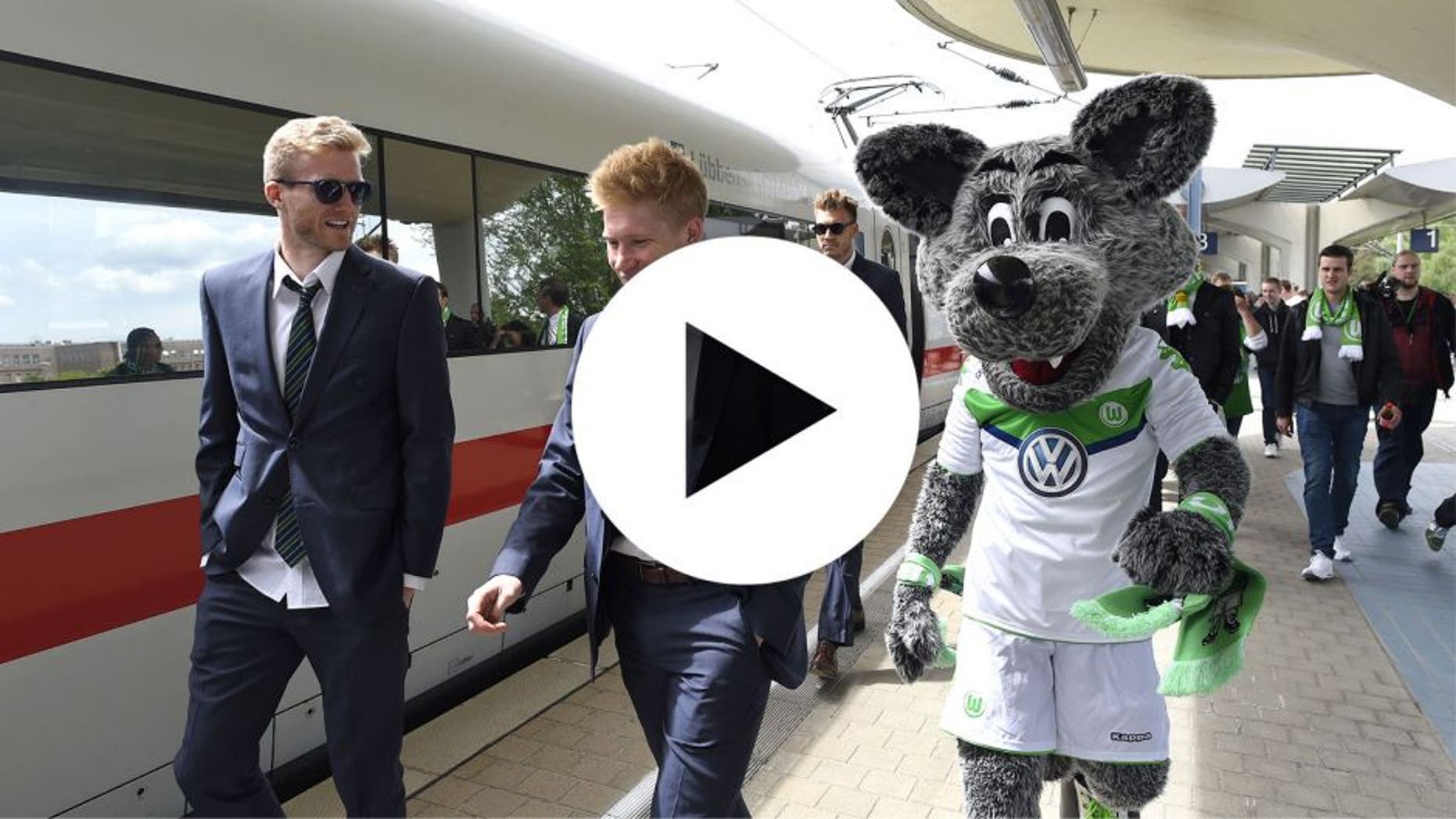 Wolfsburg's striker Andre Schuerrle (L) walks with Wolfsburg's Belgian midfielder Kevin De Bruyne and Wolfsburg's mascot on arrival at the main station in Wolfsburg, central Germany on May 31, 2015, after the German Cup DFB Pokal final football match between BVB Borussia Dortmund and VfL Wolfsburg on May 30 in Berlin. Wolfsburg won the match 1-3. AFP PHOTO / TOBIAS SCHWARZ (Photo credit should read TOBIAS SCHWARZ/AFP/Getty Images)