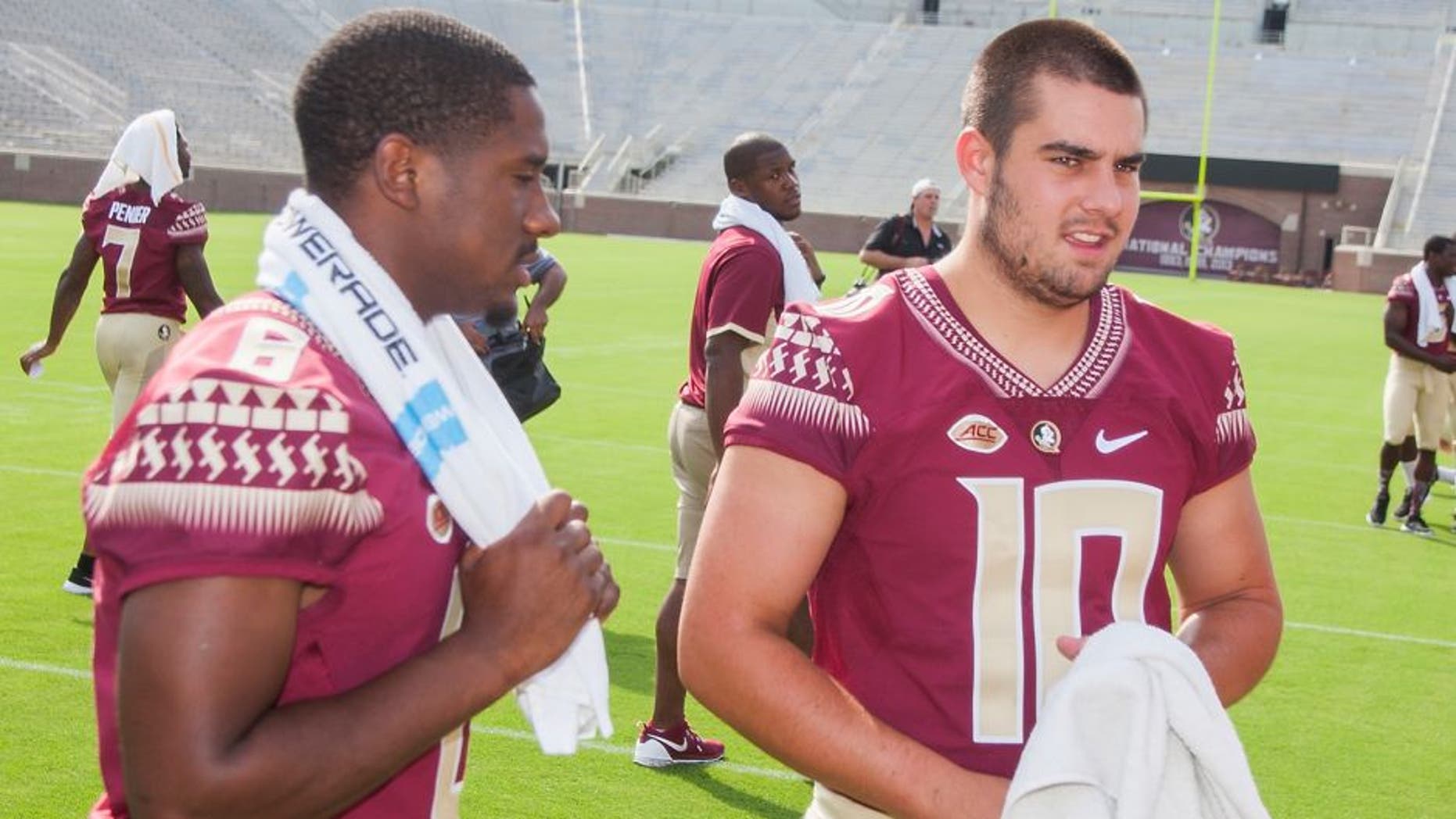 Florida State quarterbacks Everett Golson, left, and Sean Maguire await their team photo during NCAA college football media day in Tallahassee, Fla., Sunday, Aug. 9, 2015. (AP Photo/Mark Wallheiser)