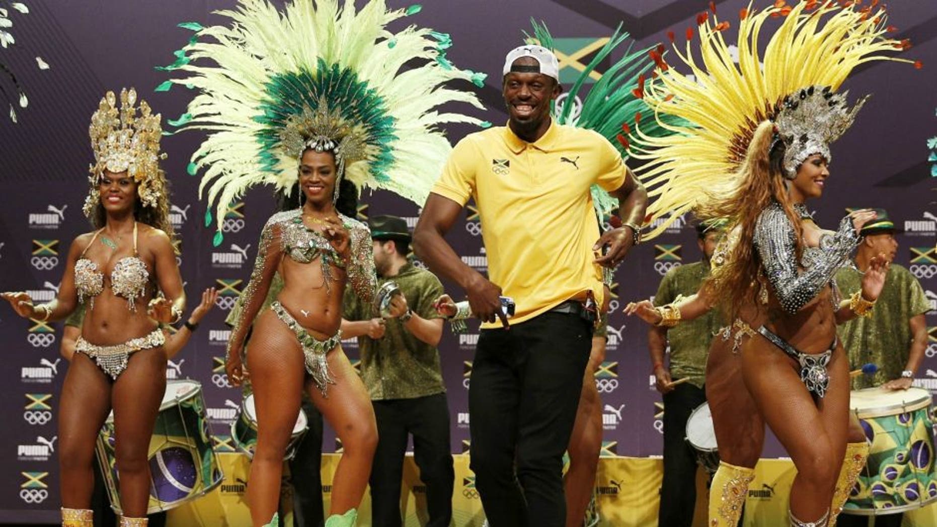 TOPSHOT - Usain Bolt (C) dances samba during a Jamaican Olympic Association and Puma press conference at the Cidade Das Artes in Rio de Janeiro on August 8, 2016. / AFP / Adrian DENNIS (Photo credit should read ADRIAN DENNIS/AFP/Getty Images)