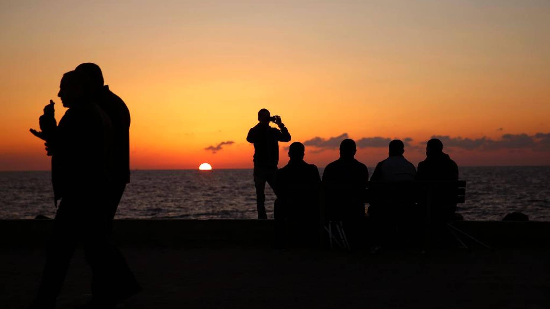 Palestinians sit on a chair during the sunset, at the Gaza port, in Gaza City, Monday, Dec. 12, 2016. The harbor is one of the few open public spaces in this densely populated city. (AP Photo/Hatem Moussa)