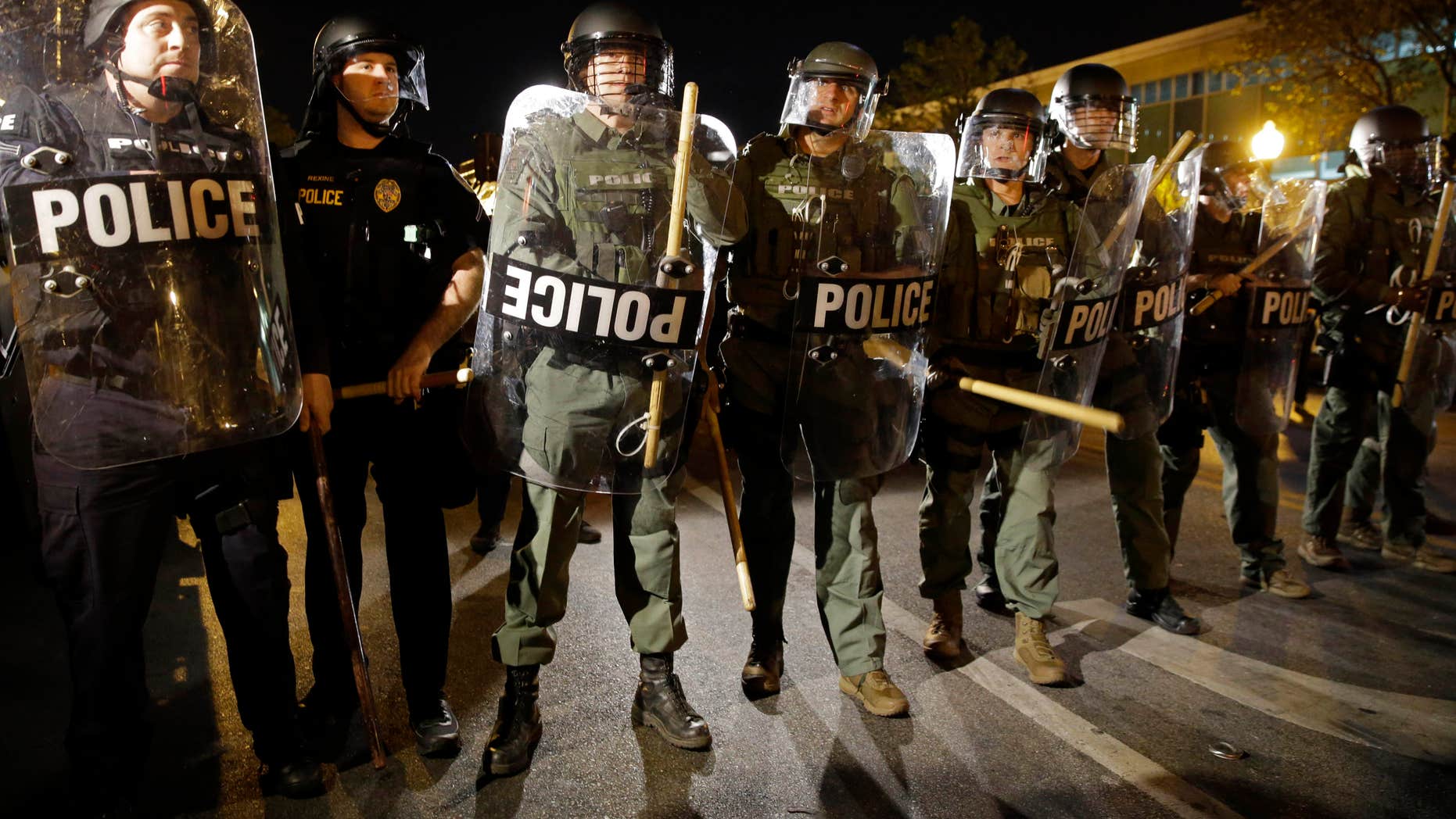 FILE - In this April 29, 2015 file photo, police stand in formation as a curfew approaches in Baltimore.