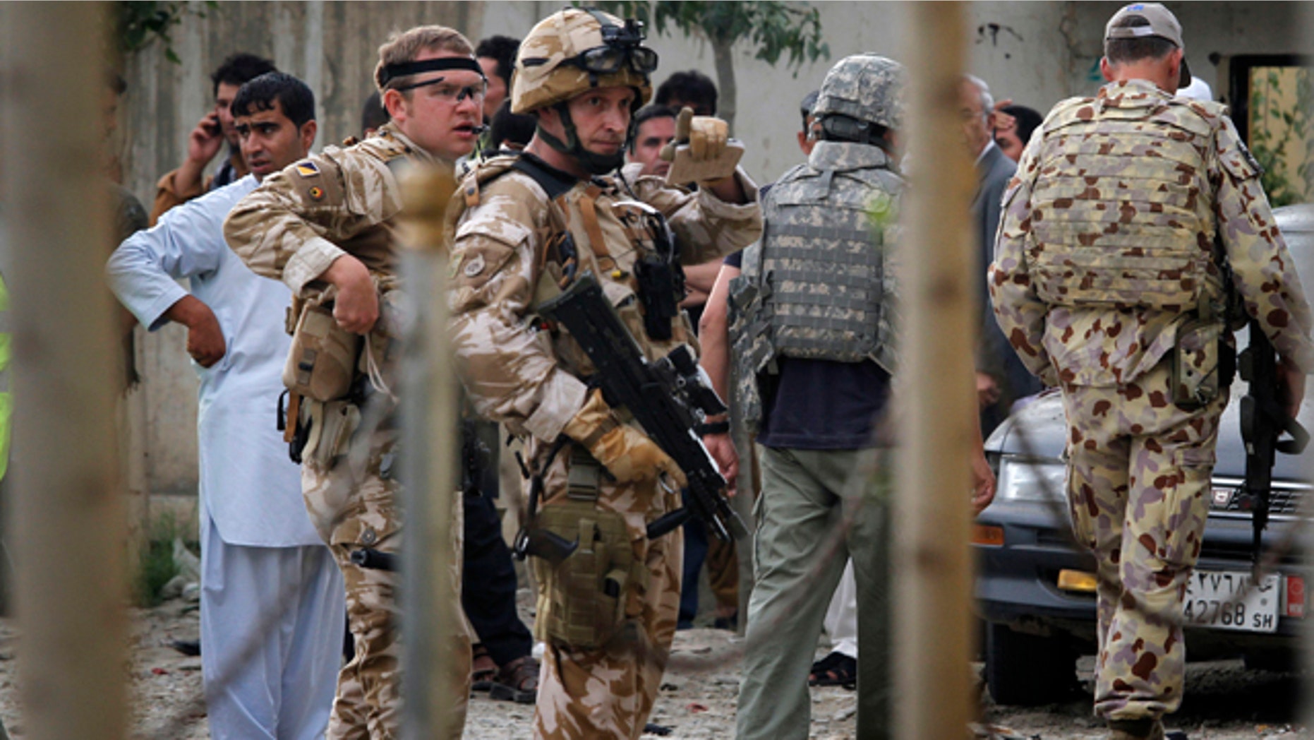 Soldiers with the NATO- led International Security Assistance Force (ISAF) arrive at the scene of a militant attack in Kabul, Afghanistan on Tuesday, Aug. 10, 2010. Two suicide attackers struck a building rented by a private security company in Afghanistan's capital Tuesday, detonating their explosive vests to kill two company drivers, police said. (AP Photo/Musadeq Sadeq)
