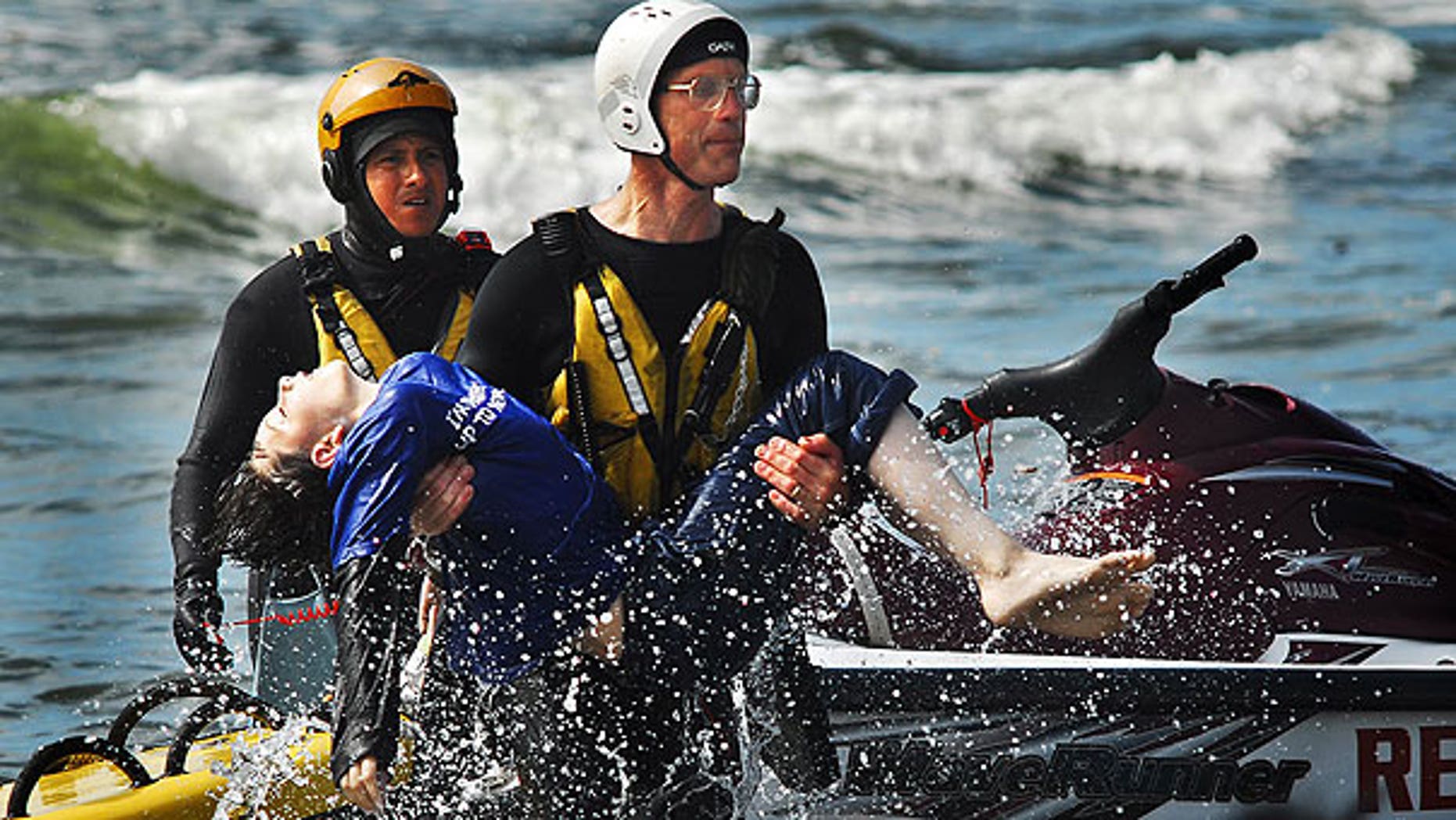August 5: Surf rescue swimmer Doug Knutzen carries Dale Ostrander to the shore of the Cranberry Rd. beach approach in Long Beach, Wash. Rescue swimmers Eddie Mendez, left, and Will Green found Ostrander in the surf.