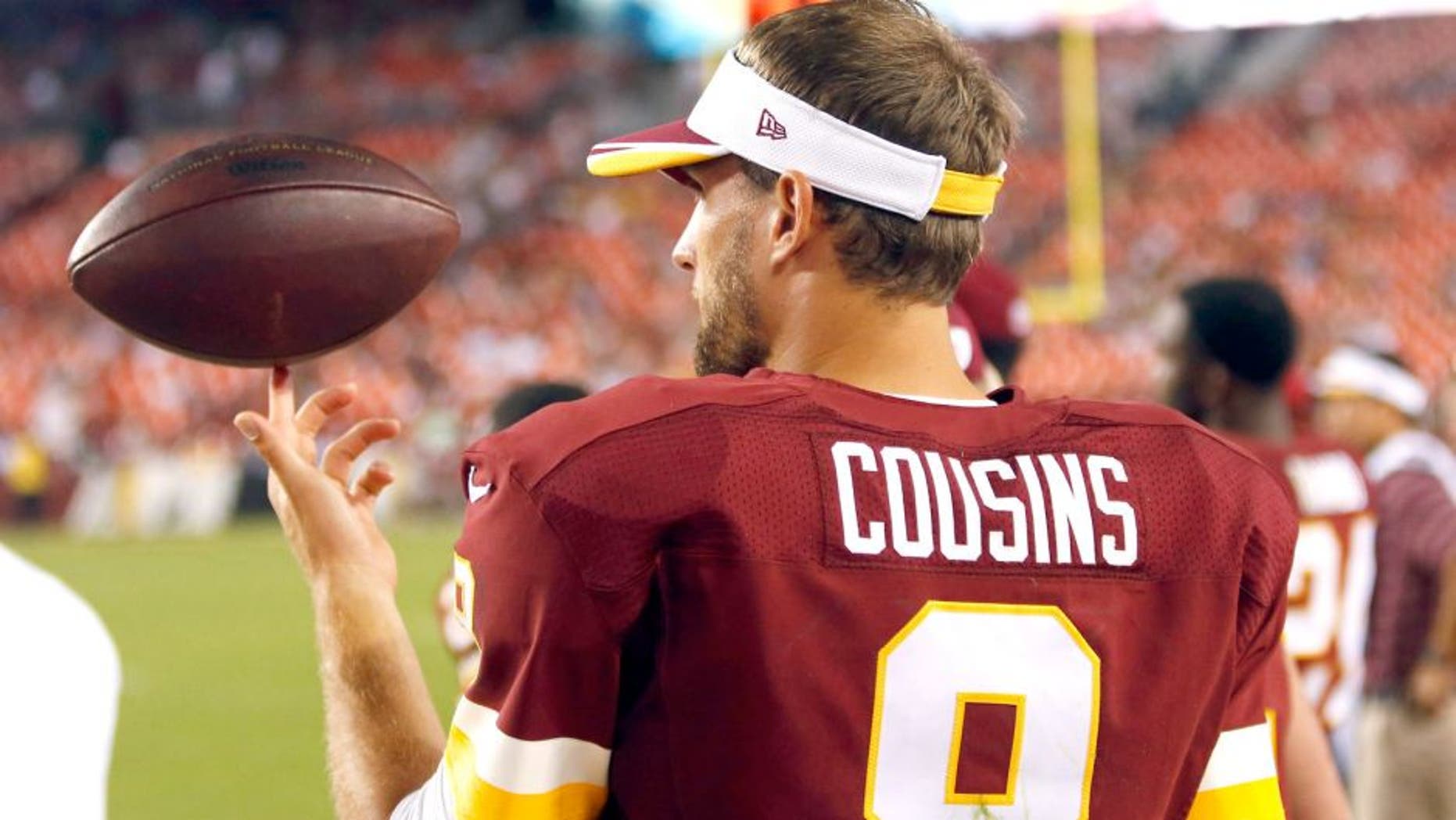 Aug 7, 2014; Landover, MD, USA; Washington Redskins quarterback Kirk Cousins (8) spins a ball on his finger on the sidelines against the New England Patriots in the third quarter at FedEx Field. The Redskins won 23-6. Mandatory Credit: Geoff Burke-USA TODAY Sports