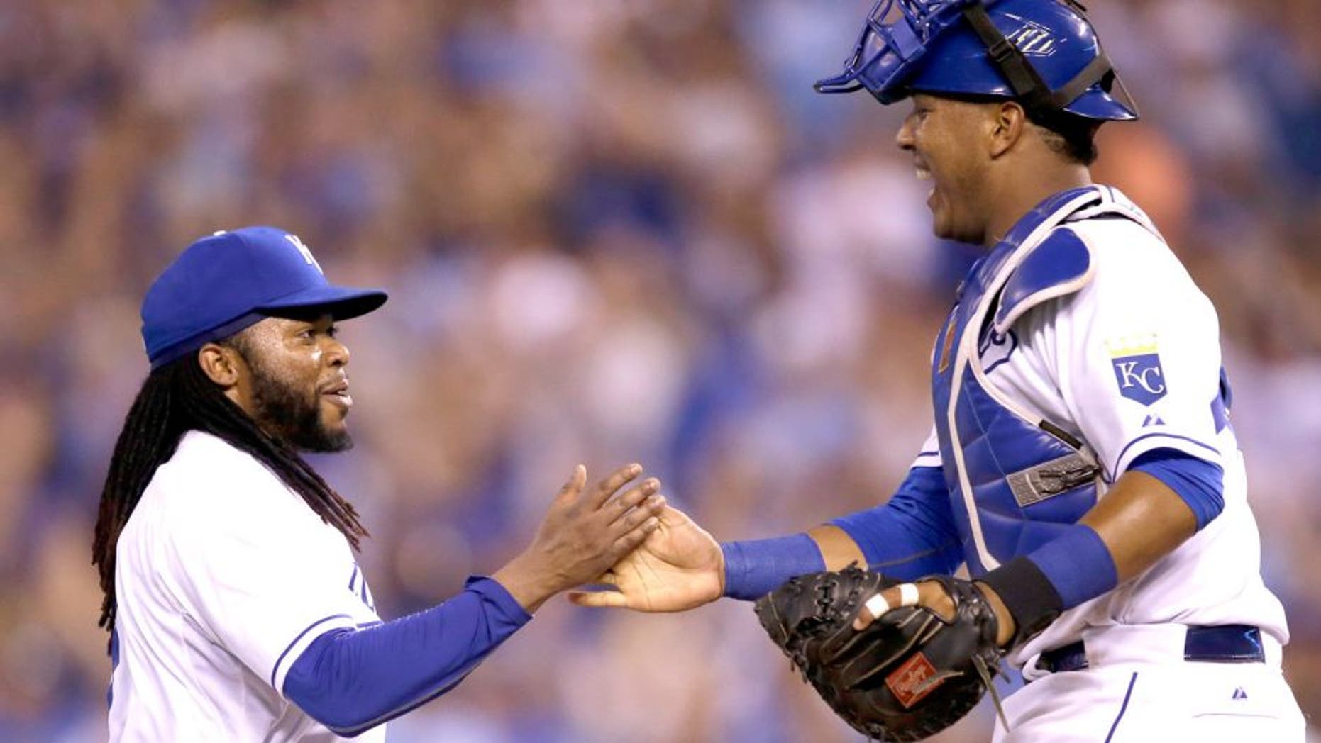 Kansas City Royals starting pitcher Johnny Cueto, left, is congratulated by catcher Salvador Perez, right, following a baseball game against the Detroit Tigers at Kauffman Stadium in Kansas City, Mo., Monday, Aug. 10, 2015. The Royals defeated the Tigers 4-0. (AP Photo/Orlin Wagner)