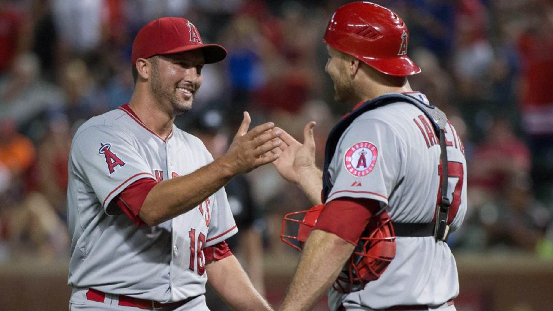 Jul 5, 2015; Arlington, TX, USA; Los Angeles Angels relief pitcher Huston Street (16) and catcher Chris Iannetta (17) celebrate the win over the Texas Rangers at Globe Life Park in Arlington. The Angels defeated the Rangers 12-6. Mandatory Credit: Jerome Miron-USA TODAY Sports