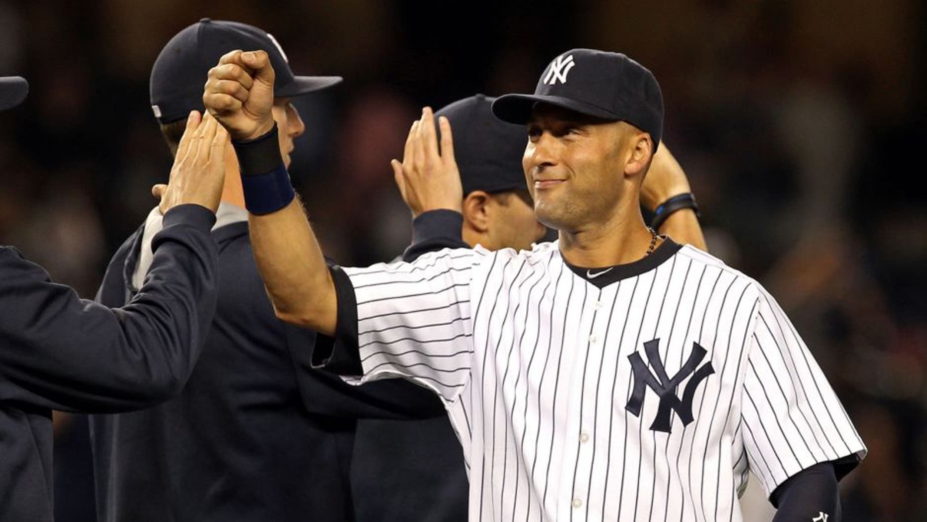 Aug 8, 2014; Bronx, NY, USA; New York Yankees shortstop Derek Jeter (2) celebrates with teammates after defeating the Cleveland Indians 10-6 at Yankee Stadium. Mandatory Credit: Adam Hunger-USA TODAY Sports