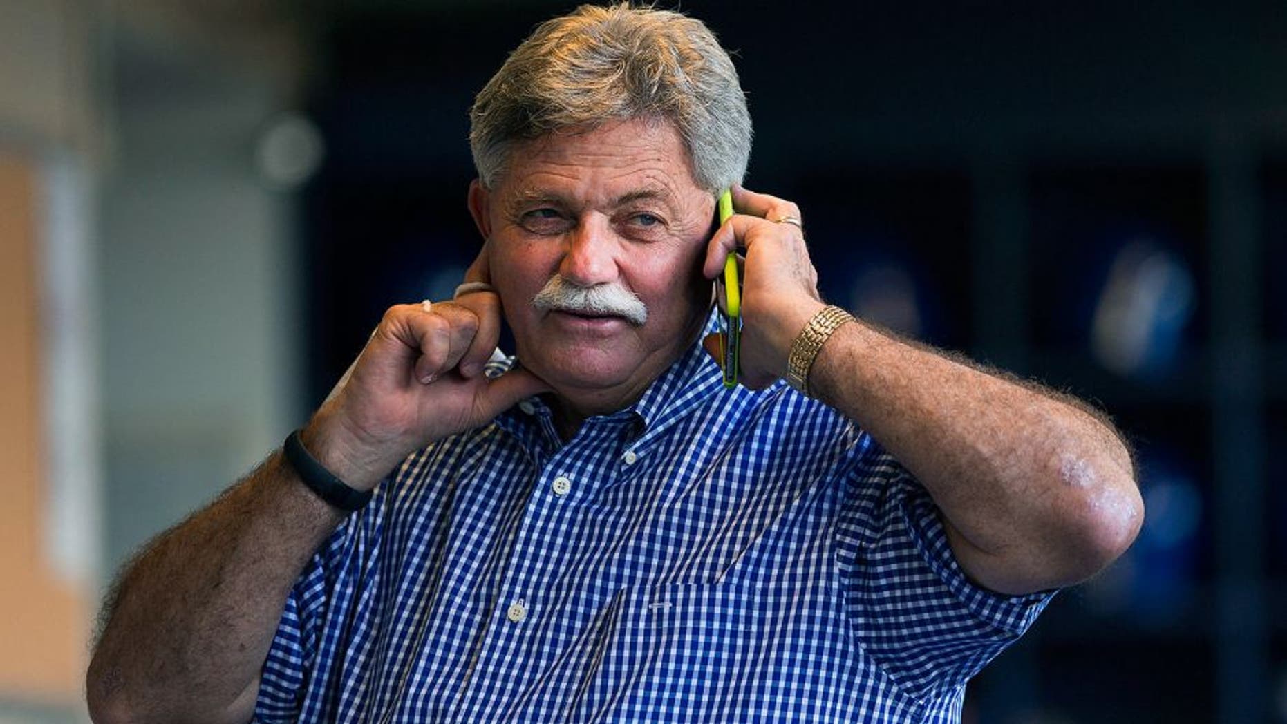 Jul 31, 2015; Milwaukee, WI, USA; Milwaukee Brewers general manager Doug Melvin talks on the phone from the dugout during batting practice prior to the game against the Chicago Cubs at Miller Park. Mandatory Credit: Jeff Hanisch-USA TODAY Sports