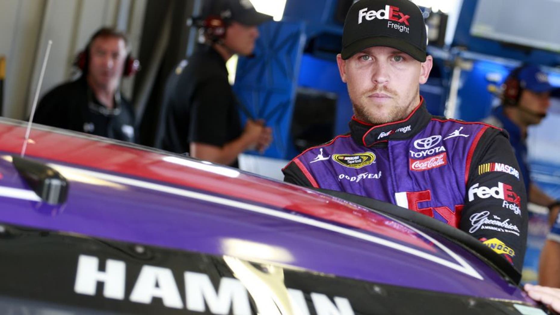 SPARTA, KY - JULY 07: Denny Hamlin, driver of the #11 FedEx Freight Toyota, stands in the garage area during practice for the NASCAR Sprint Cup Series Quaker State 400 at Kentucky Speedway on July 7, 2016 in Sparta, Kentucky. (Photo by Matt Sullivan/Getty Images)