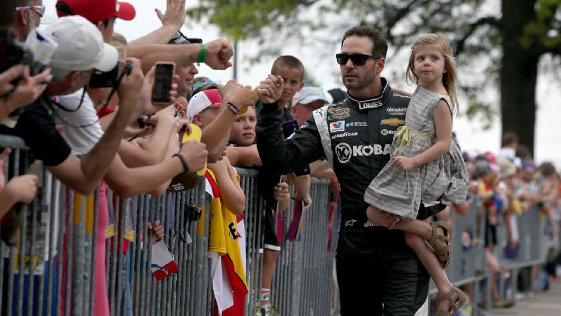 INDIANAPOLIS, IN - JULY 26: Jimmie Johnson, driver of the #48 Kobalt Tools Chevrolet, and his daughter Genevieve walk along The Yard of Bricks prior to being introduced for the NASCAR Sprint Cup Series Crown Royal Presents the Jeff Kyle 400 at the Brickyard at Indianapolis Motor Speedway on July 26, 2015 in Indianapolis, Indiana. (Photo by Sean Gardner/NASCAR via Getty Images)