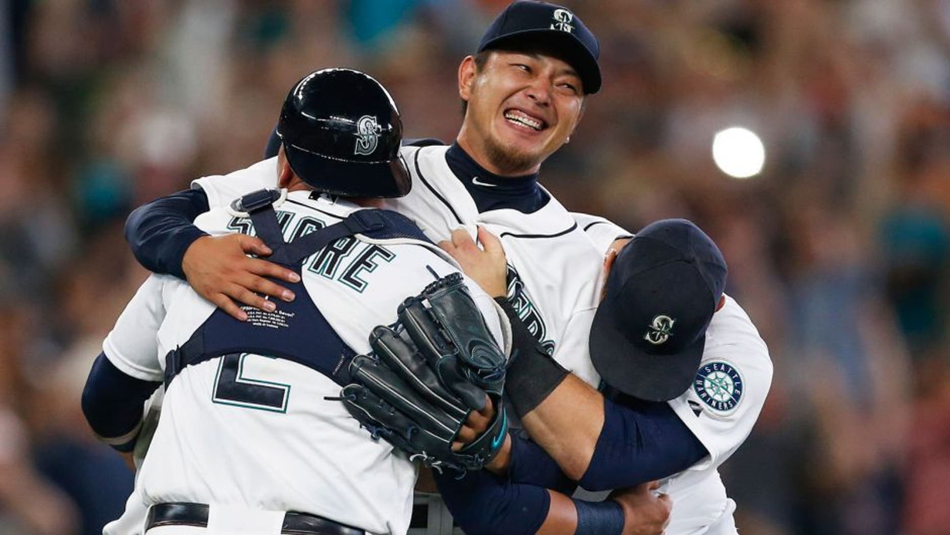 Aug 12, 2015; Seattle, WA, USA; Seattle Mariners pitcher Hisashi Iwakuma (18, center) celebrates with his teammates following the final out of his no-hit, 3-0 victory against the Baltimore Orioles at Safeco Field. Mandatory Credit: Joe Nicholson-USA TODAY Sports