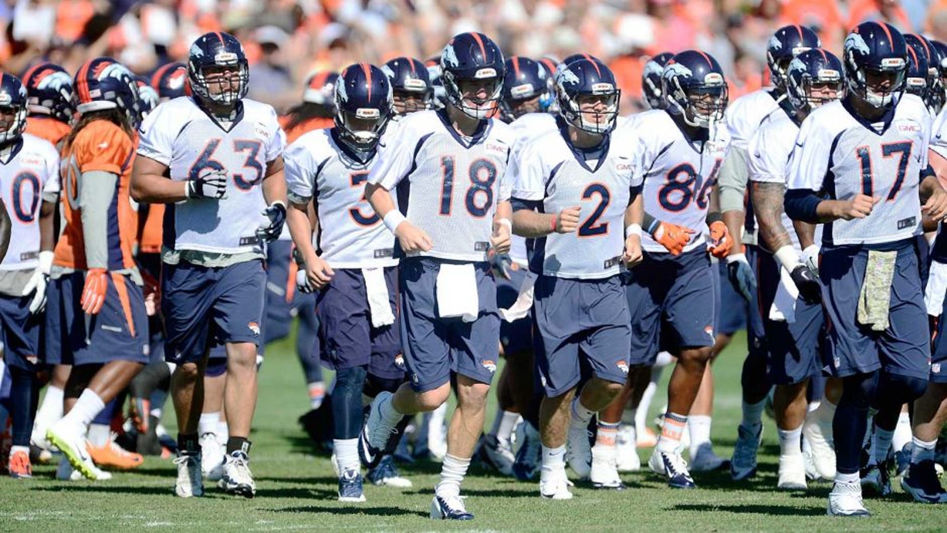Aug 12, 2015; Englewood, CO, USA; Denver Broncos quarterback Peyton Manning (18), guard Ben Garland (63), quarterback Zac Dysert (2) and quarterback Brock Osweiler (17) warm up during training camp activities at the UCHealth Training Center. Mandatory Credit: Ron Chenoy-USA TODAY Sports