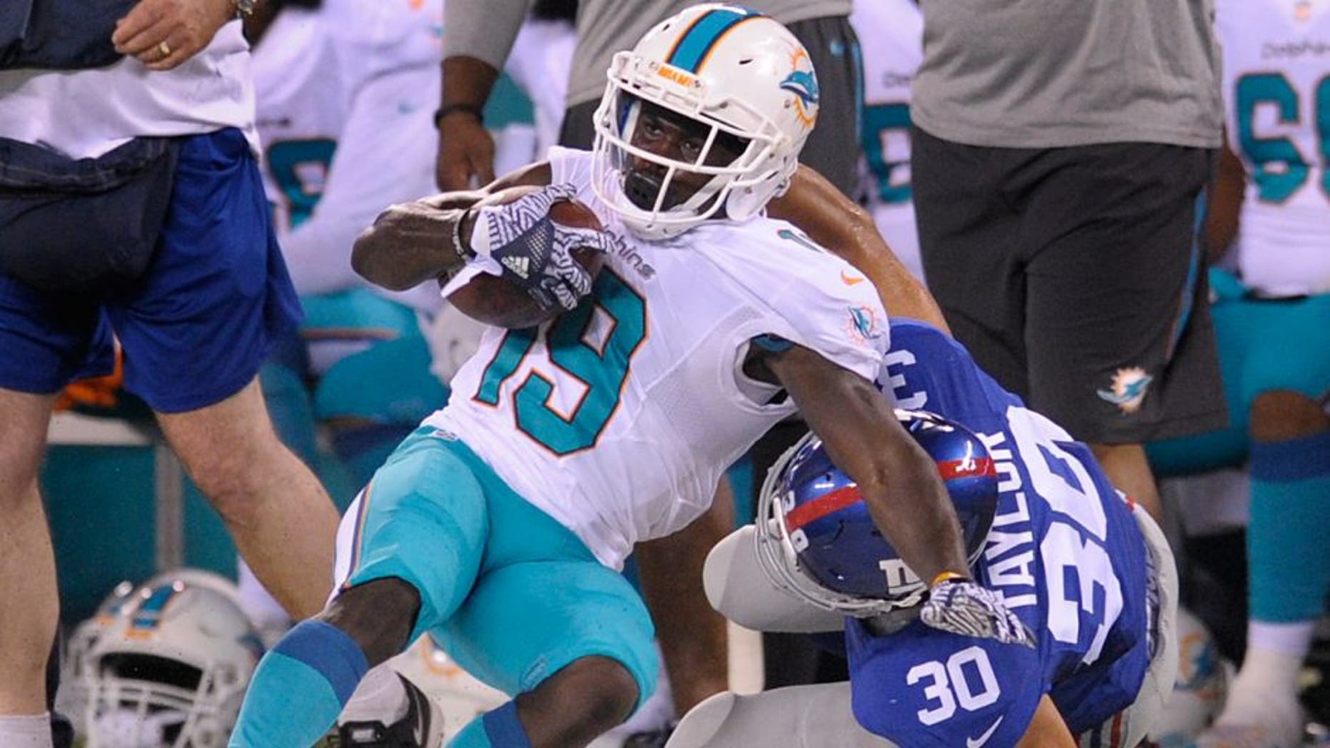 Miami Dolphins wide receiver Jakeem Grant (19) is tackled by New York Giants defensive back Cooper Taylor (30) during the third quarter of a preseason NFL football game, Friday, Aug. 12, 2016, in East Rutherford, N.J. (AP Photo/Bill Kostroun)