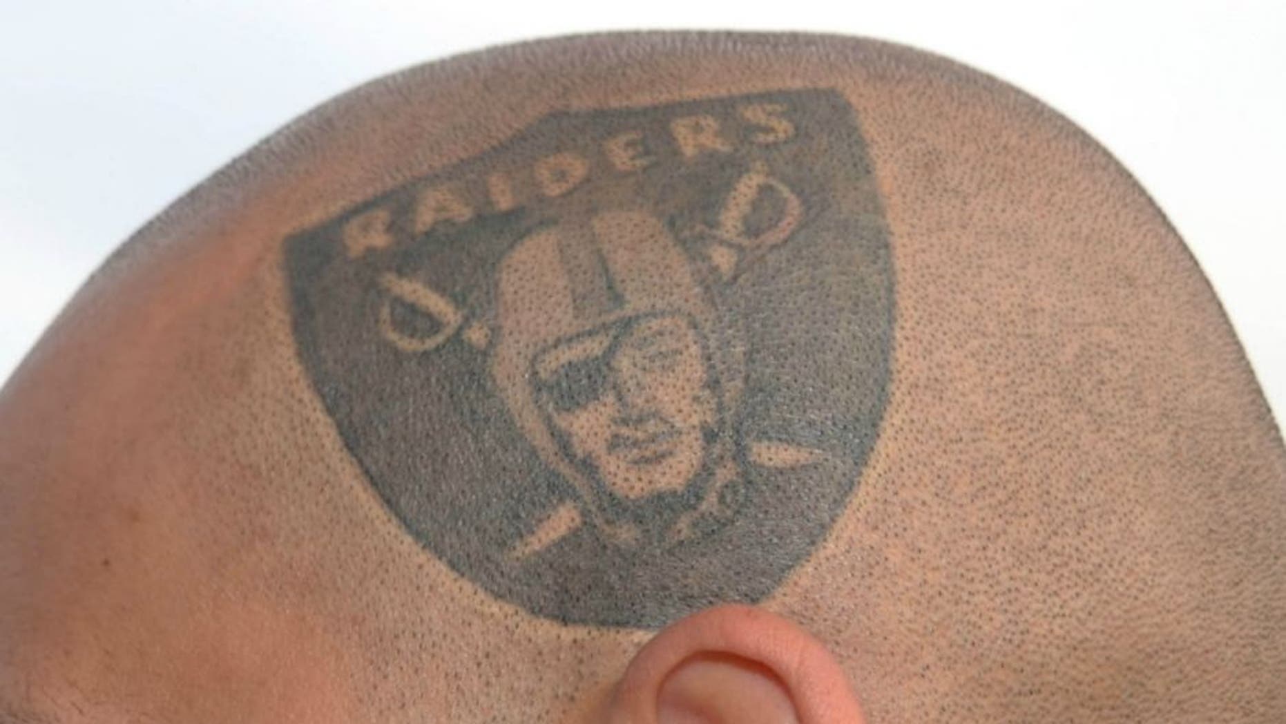 Oct 21, 2012; Oakland, CA, USA; Oakland Raiders fan Rico Espinoza poses with a Raiders tattoo on the side of his head before the game against the Jacksonville Jaguars at O.co Coliseum. Mandatory Credit: Kirby Lee/Image of Sport-US PRESSWIRE