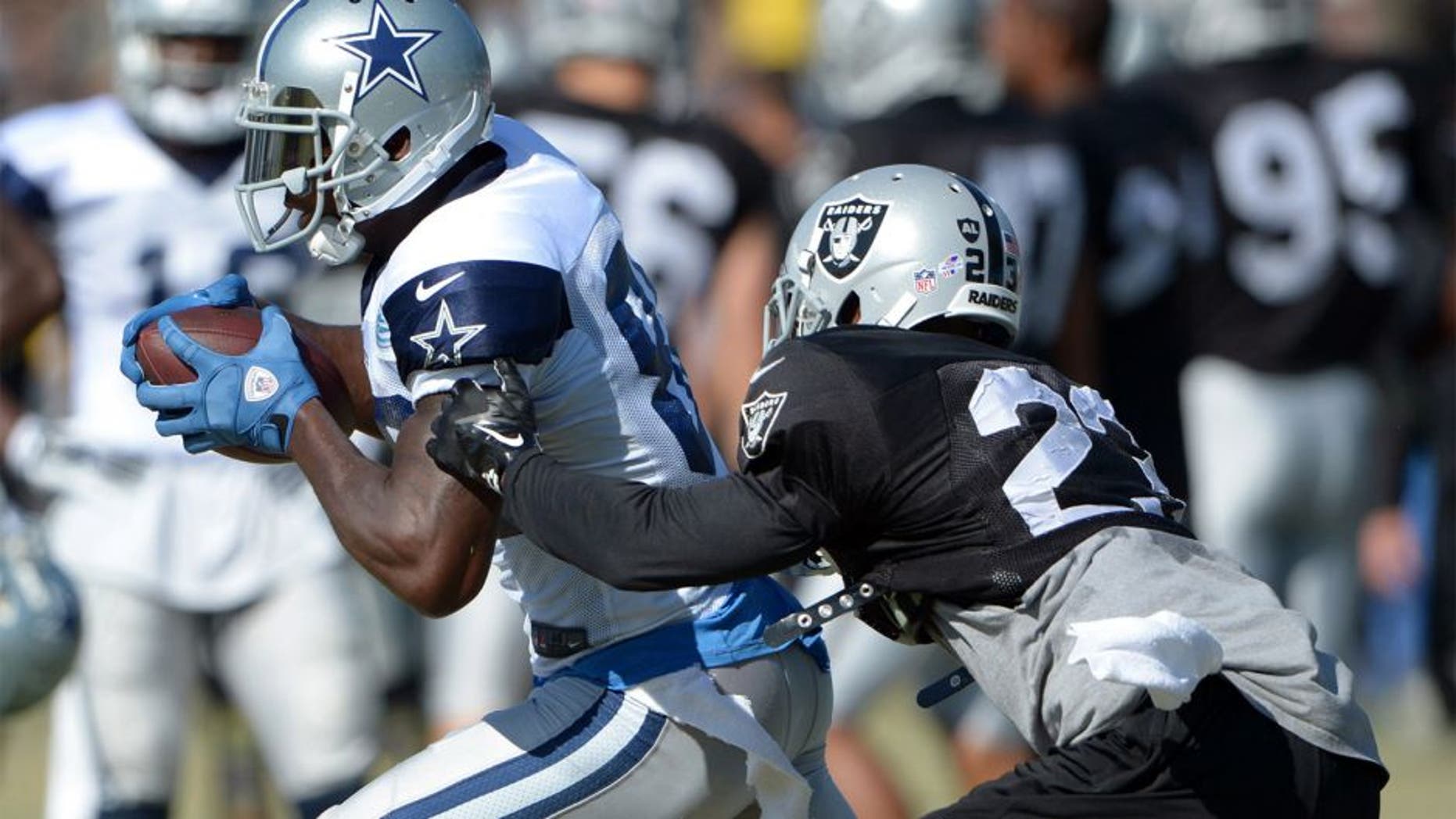 Aug 12, 2014; Oxnard, CA, USA; Dallas Cowboys receiver Dez Bryant (88) is defended by Oakland Raiders cornerback Tarell Brown (23) at scrimmage against the Oakland Raiders at River Ridge Fields. Mandatory Credit: Kirby Lee-USA TODAY Sports