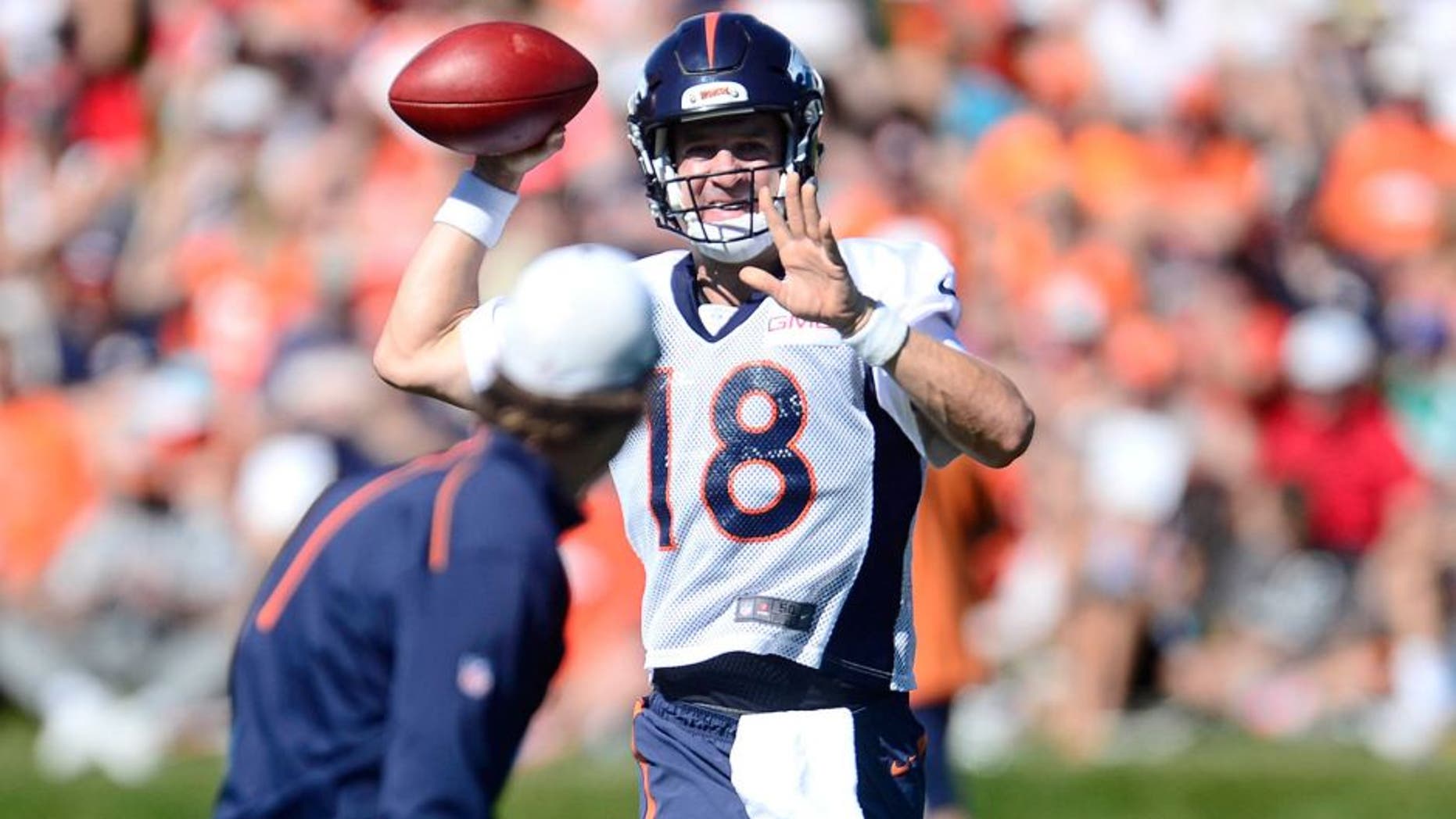 Aug 12, 2015; Englewood, CO, USA; Denver Broncos quarterback Peyton Manning (18) warms up with passing drills during training camp activities at the UCHealth Training Center. Mandatory Credit: Ron Chenoy-USA TODAY Sports