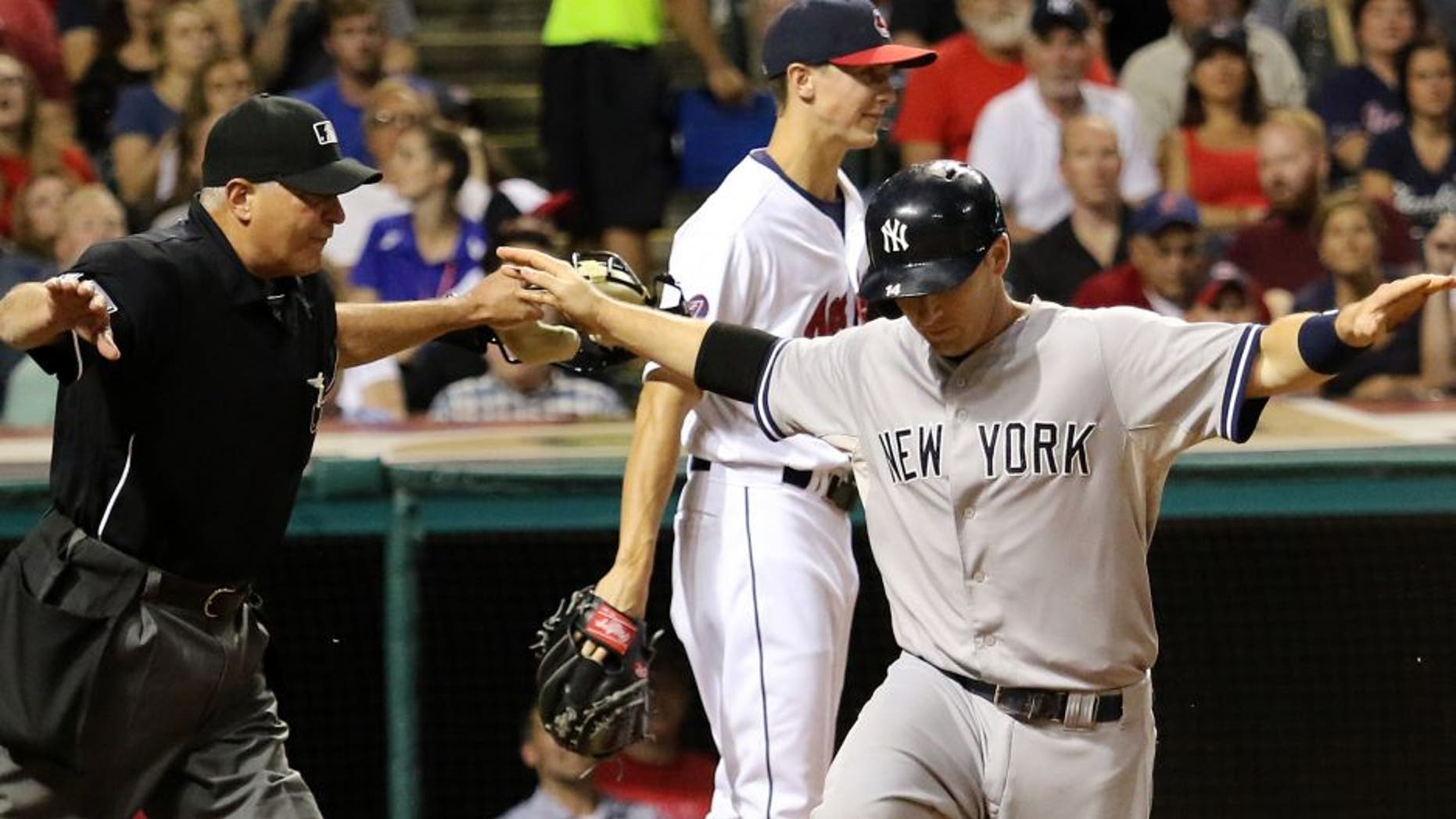 New York Yankees Stephen Drew, right, and umpire John Hirschbeck both signal that Drew is safe, after he scored on a single by Brad Gardner duirng the sixth inning