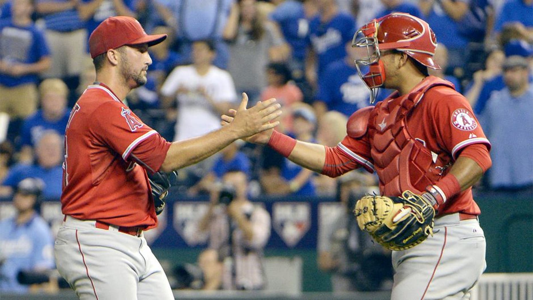 Aug 13, 2015; Kansas City, MO, USA; Los Angeles Angels relief pitcher Huston Street (16) celebrates with catcher Carlos Perez (58) after the game against the Kansas City Royals at Kauffman Stadium. The Angels won the game 7-6. Mandatory Credit: John Rieger-USA TODAY Sports