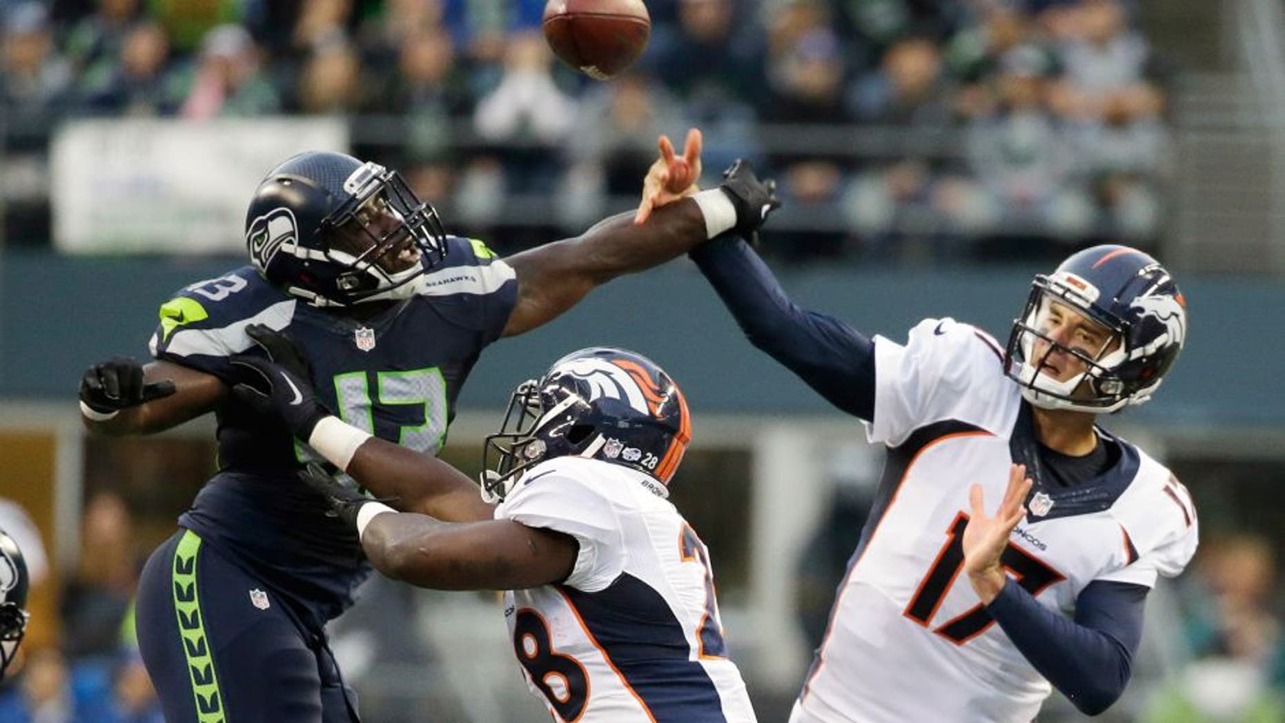Seattle Seahawks linebacker Quayshawn Nealy (43) tries to deflect a pass by Denver Broncos quarterback Brock Osweiler (17) as Broncos running back Montee Ball, center, blocks. during the first half of a preseason NFL football game, Friday, Aug. 14, 2015, in Seattle. (AP Photo/Elaine Thompson)