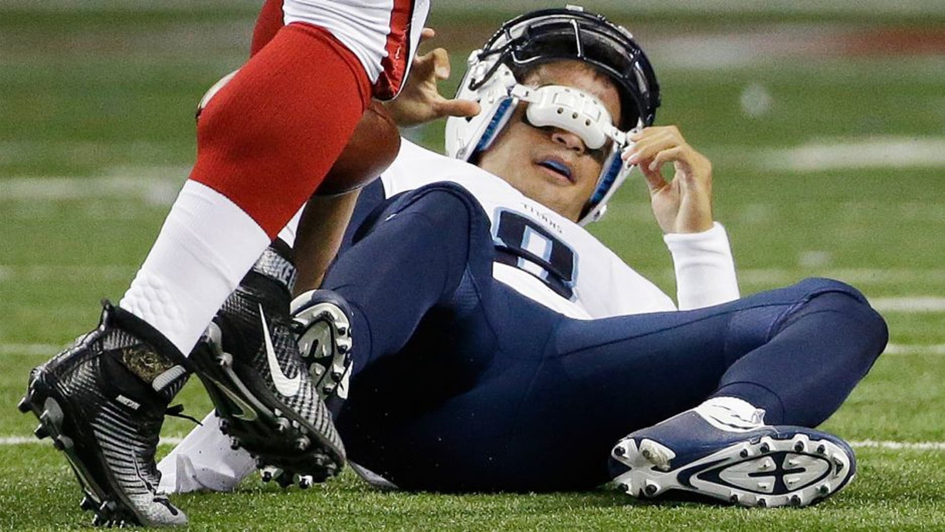 Tennessee Titans quarterback Marcus Mariota (8) lies on the field after being sacked by Atlanta Falcons defensive tackle Tyson Jackson (94) during the first half of an NFL football preseason game , Friday, Aug. 14, 2015, in Atlanta. (AP Photo/David Goldman)