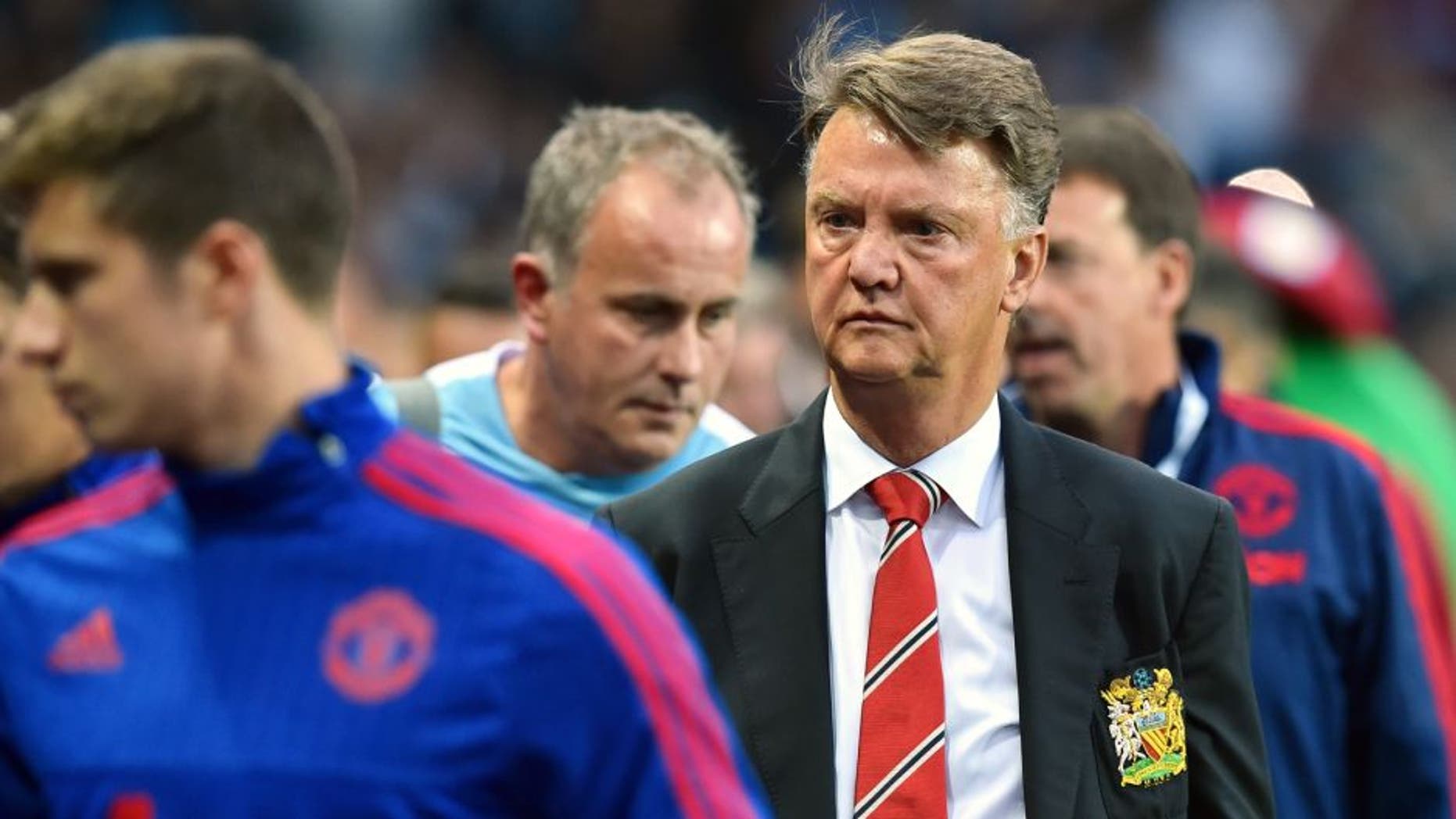 Manchester United's Dutch manager Louis van Gaal (2nd R) arrives for the start of the English Premier League football match between Aston Villa and Manchester United at Villa Park in Birmingham, central England, on August 14, 2015. AFP PHOTO / BEN STANSALL RESTRICTED TO EDITORIAL USE. No use with unauthorized audio, video, data, fixture lists, club/league logos or 'live' services. Online in-match use limited to 75 images, no video emulation. No use in betting, games or single club/league/player publications. (Photo credit should read BEN STANSALL/AFP/Getty Images)