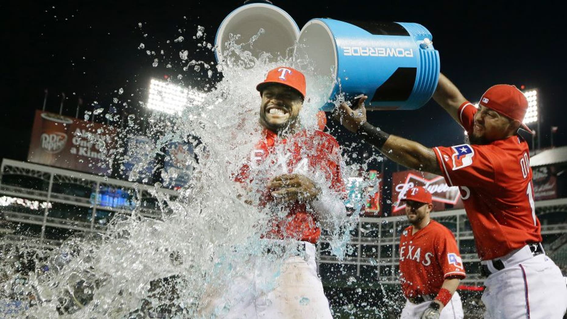 Texas Rangers Delino DeShields, left, gets doused with the drink cooler by teammate Rougned Odor after a baseball game against the Tampa Bay Rays in Arlington, Texas, Friday, Aug. 14, 2015. The Rangers won 5-3. (AP Photo/LM Otero)