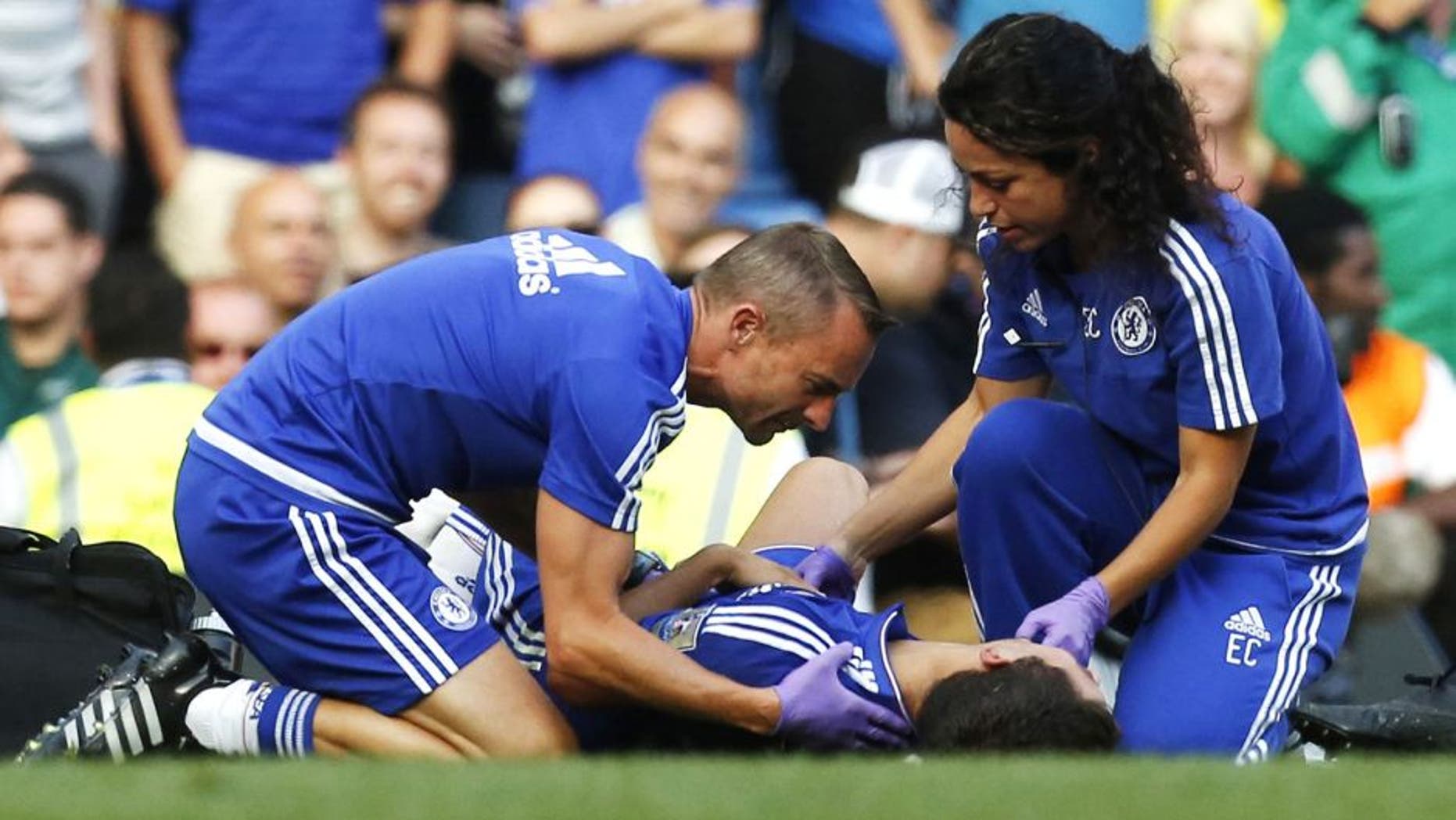 Chelsea doctor (R) Eva Carneiro and head physio Jon Fearn (L) treat Chelsea's Belgian midfielder Eden Hazard late on during the English Premier League football match between Chelsea and Swansea City at Stamford Bridge in London on August 8, 2015. Chelsea have sidelined team doctor Eva Carneiro from match-day duties after she fell foul of manager Jose Mourinho, according to British media reports on August 11, 2015. Mourinho criticised Carneiro after she ran on the pitch to treat Eden Hazard in stoppage time of Chelsea's 2-2 draw at home to Swansea City on August 8, saying she did not "understand the game". AFP PHOTO / IAN KINGTON RESTRICTED TO EDITORIAL USE. No use with unauthorized audio, video, data, fixture lists, club/league logos or 'live' services. Online in-match use limited to 75 images, no video emulation. No use in betting, games or single club/league/player publications. (Photo credit should read IAN KINGTON/AFP/Getty Images)