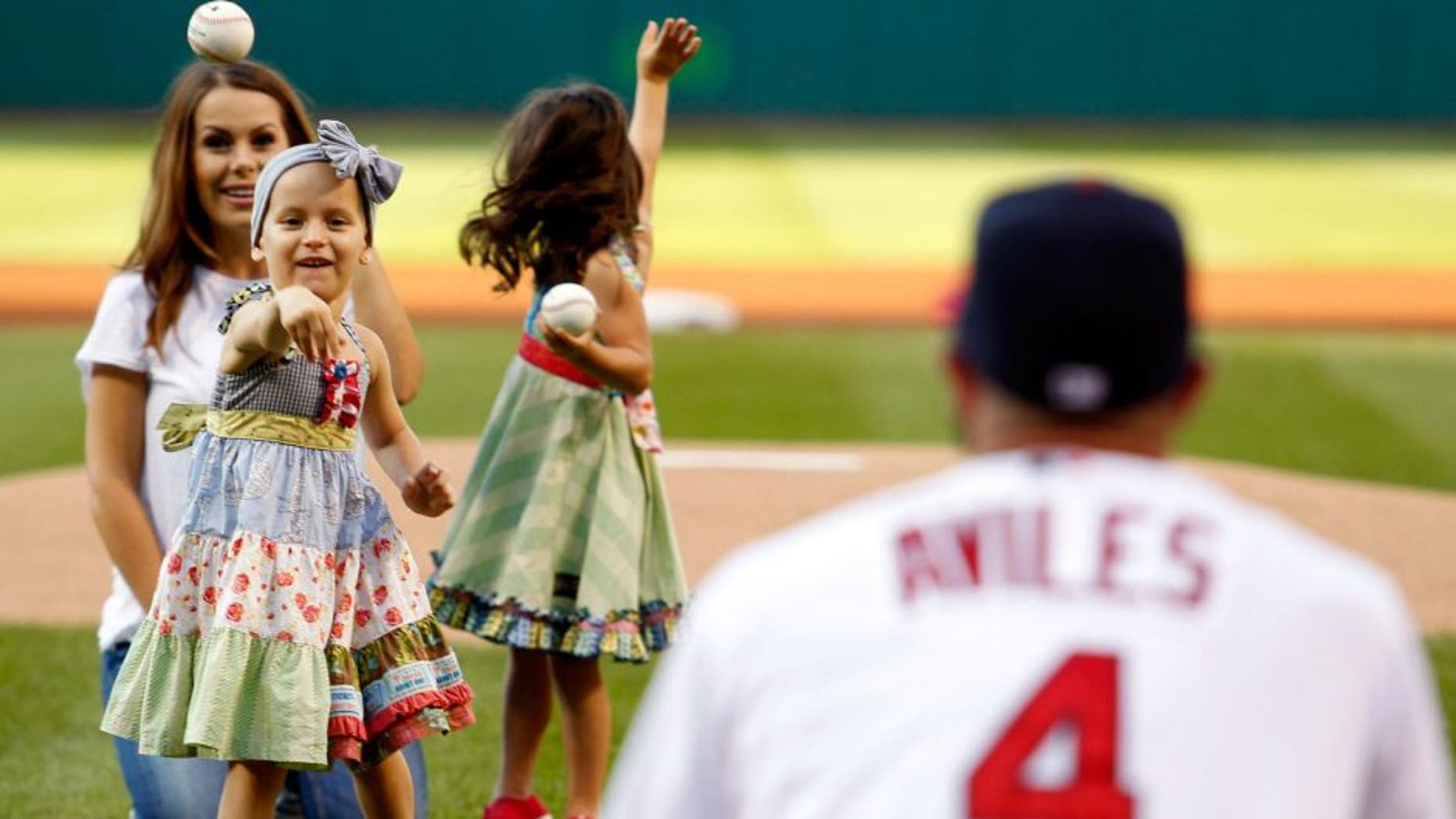 Cleveland Indians' Mike Aviles catches the ceremonial first pitch from his daughter Adriana as his wife, Jessy, watches prior to the Indians' baseball game against the New York Yankees on Thursday, Aug.13, 2015, in Cleveland. (AP Photo/Aaron Josefczyk