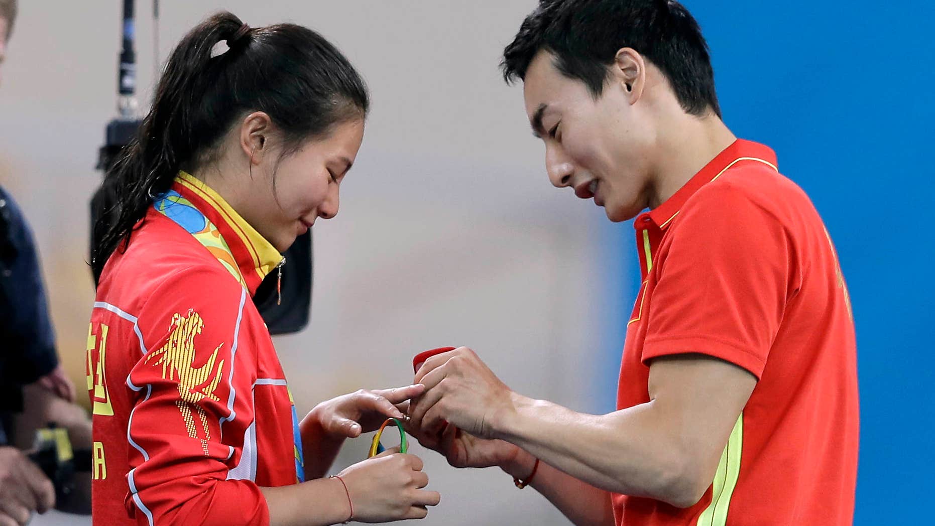 Aug. 14, 2016: China's silver medalist He Zi, left, receivers a marriage proposal by China's diver Qin Ki, right, during the medal ceremony for the the women's 3-meter springboard diving final in the Maria Lenk Aquatic Center at the 2016 Summer Olympics in Rio de Janeiro, Brazil