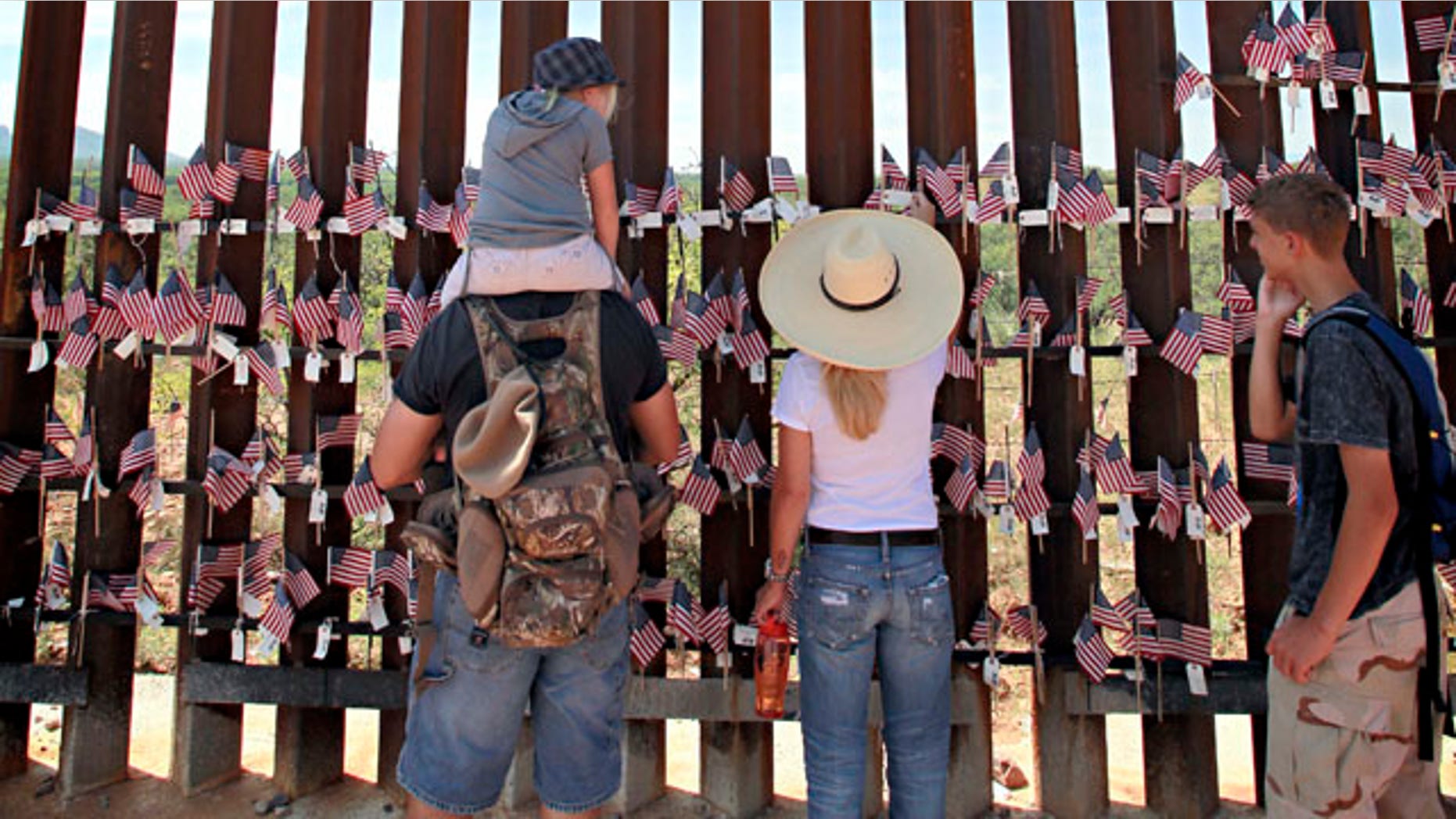 Aug. 15: From left; Steven Nanatovich, Jennifer Nanatovich, 7, Alexa Nanatovich, and Russell Nanatovich look at the flags on the Arizona-Mexico border wall in Hereford, Ariz.