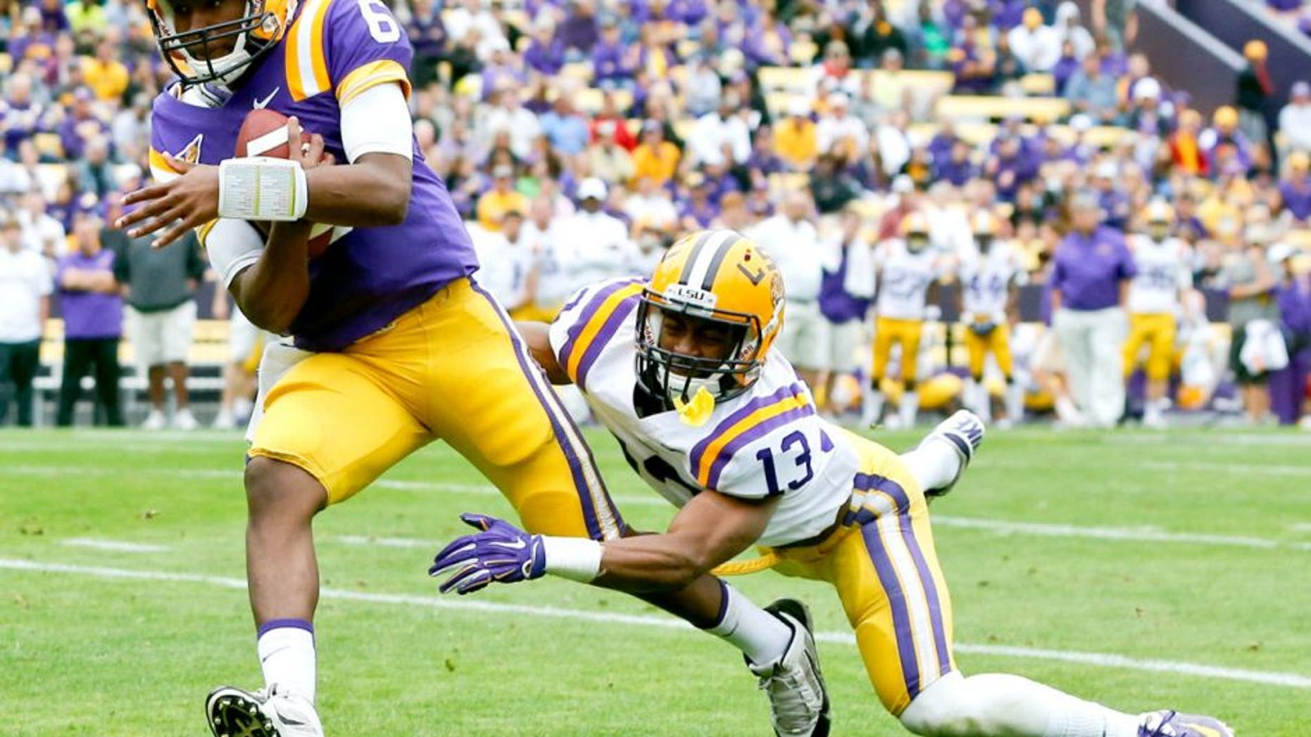 Apr 5, 2014; Baton Rouge, LA, USA; LSU Tigers quarterback Brandon Harris (6) runs for a touchdown past cornerback Dwayne Thomas (13) during the 2014 spring game at Tiger Stadium. Mandatory Credit: Derick E. Hingle-USA TODAY Sports