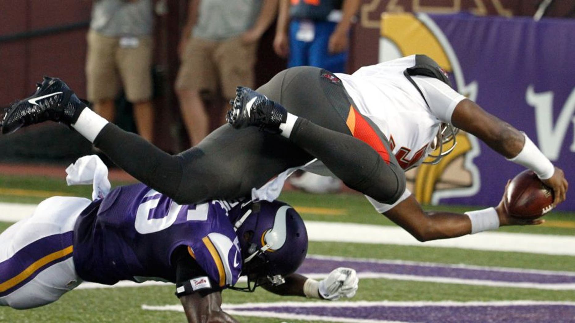 Tampa Bay Buccaneers quarterback Jameis Winston (3) dives over Minnesota Vikings cornerback Jabari Price (25) for an 8-yard touchdown during the first half of a preseason NFL football game Saturday, Aug. 15, 2015, in Minneapolis. (AP Photo/Ann Heisenfelt)