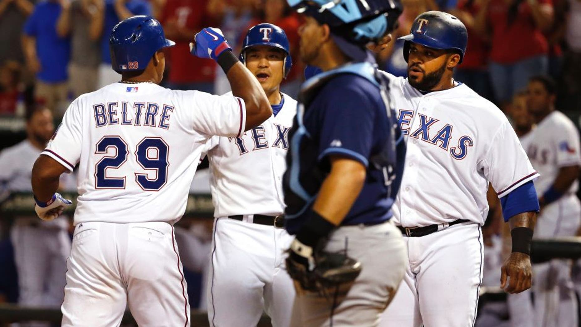 Texas Rangers third baseman Adrian Beltre (29) celebrates with teammates Shin-Soo Choo, center, and Prince Fielder after his three-run home run, while Tampa Bay Rays catcher Rene Rivera stands nearby during the sixth inning of a baseball game Saturday, Aug. 15, 2015, in Arlington, Texas. The Rangers defeated the Rays 12-4. (AP Photo/Ron Jenkins)