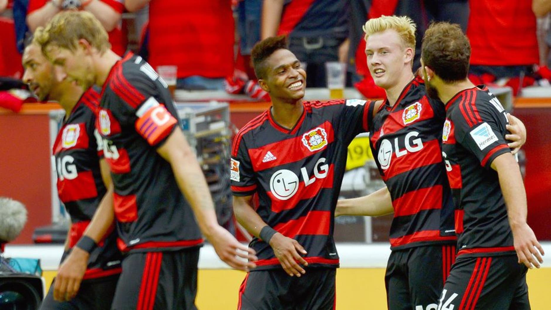 Leverkusen's midfielder Julian Brandt (2nd R) celebrates with Leverkusen's Swiss forward Admir Mehmedi (R) and Leverkusen's Brazilian defender Wendell after scoring 2-1 during the German first division Bundesliga football match Bayer 04 Leverkusen vs TSG 1899 Hoffenheim in Leverkusen, western Germany, on August 15, 2015. AFP PHOTO / SASCHA SCHUERMANN RESTRICTIONS: DURING MATCH TIME: DFL RULES TO LIMIT THE ONLINE USAGE TO 15 PICTURES PER MATCH AND FORBID IMAGE SEQUENCES TO SIMULATE VIDEO. == RESTRICTED TO EDITORIAL USE == FOR FURTHER QUERIES PLEASE CONTACT DFL DIRECTLY AT + 49 69 650050. (Photo credit should read SASCHA SCHUERMANN/AFP/Getty Images)