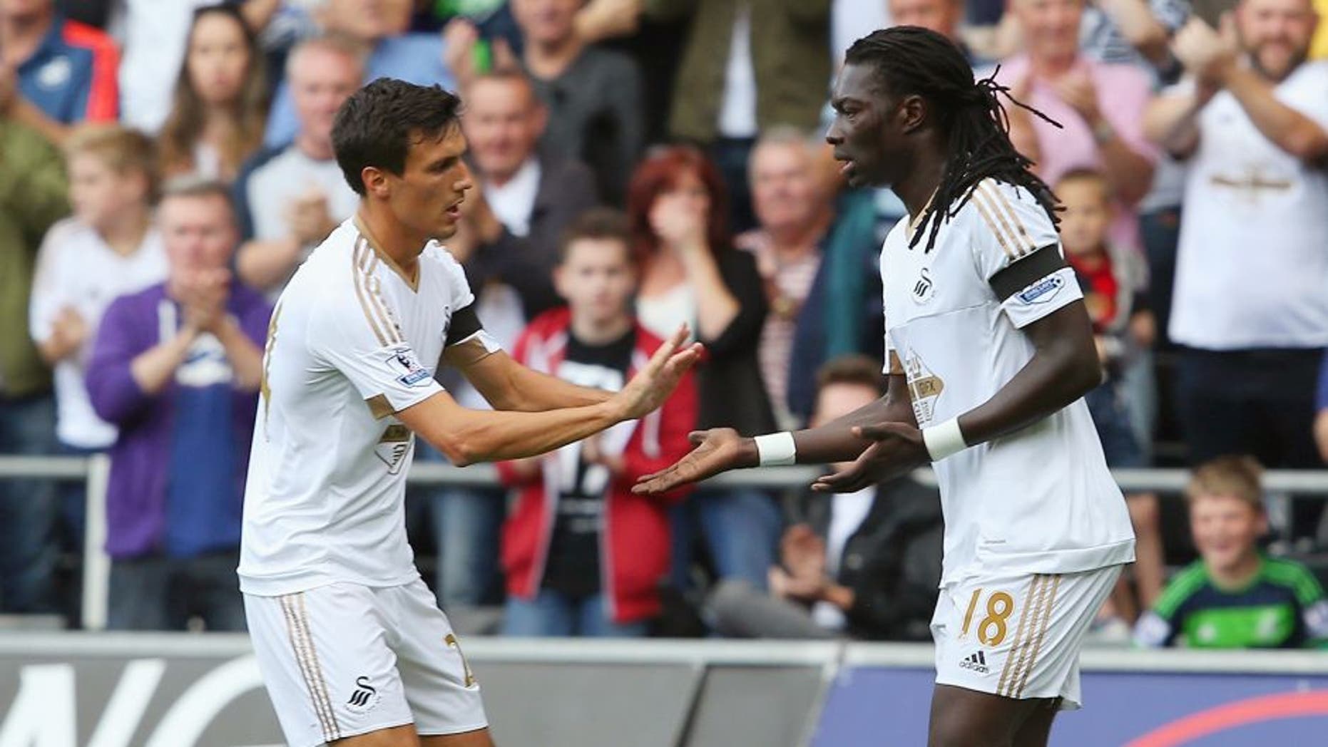 SWANSEA, WALES - AUGUST 15: Bafetimbi Gomis of Swansea City celebrates scoring his team's first goal with his team mate Jack Cork during the Barclays Premier League match between Swansea City and Newcastle United at Liberty Stadium on August 15, 2015 in Swansea, United Kingdom. (Photo by Jan Kruger/Getty Images)