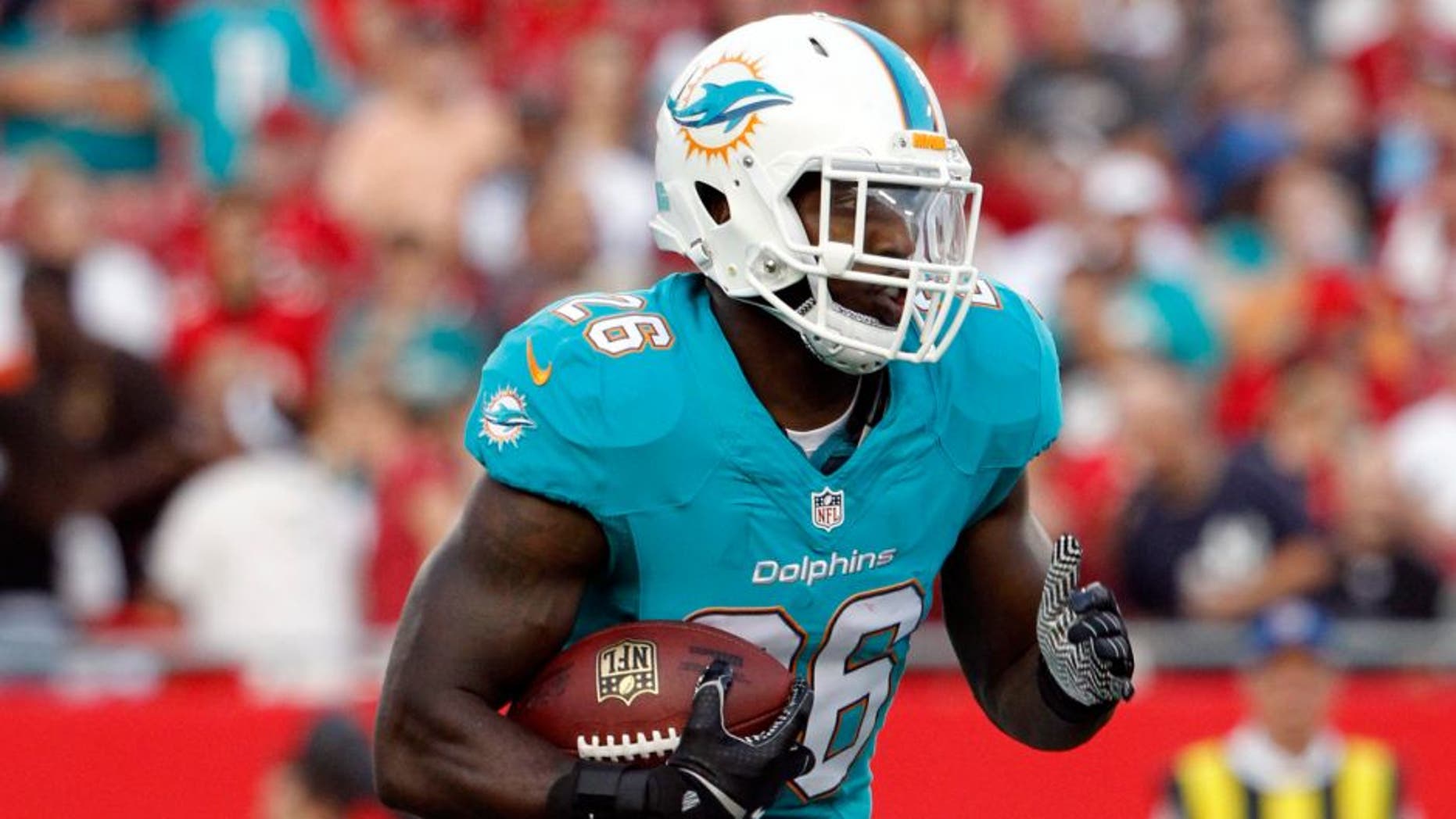 Aug 16, 2014; Tampa, FL, USA; Miami Dolphins running back Lamar Miller (26) runs with the ball during the first quarter against the Tampa Bay Buccaneers at Raymond James Stadium. Mandatory Credit: Kim Klement-USA TODAY Sports