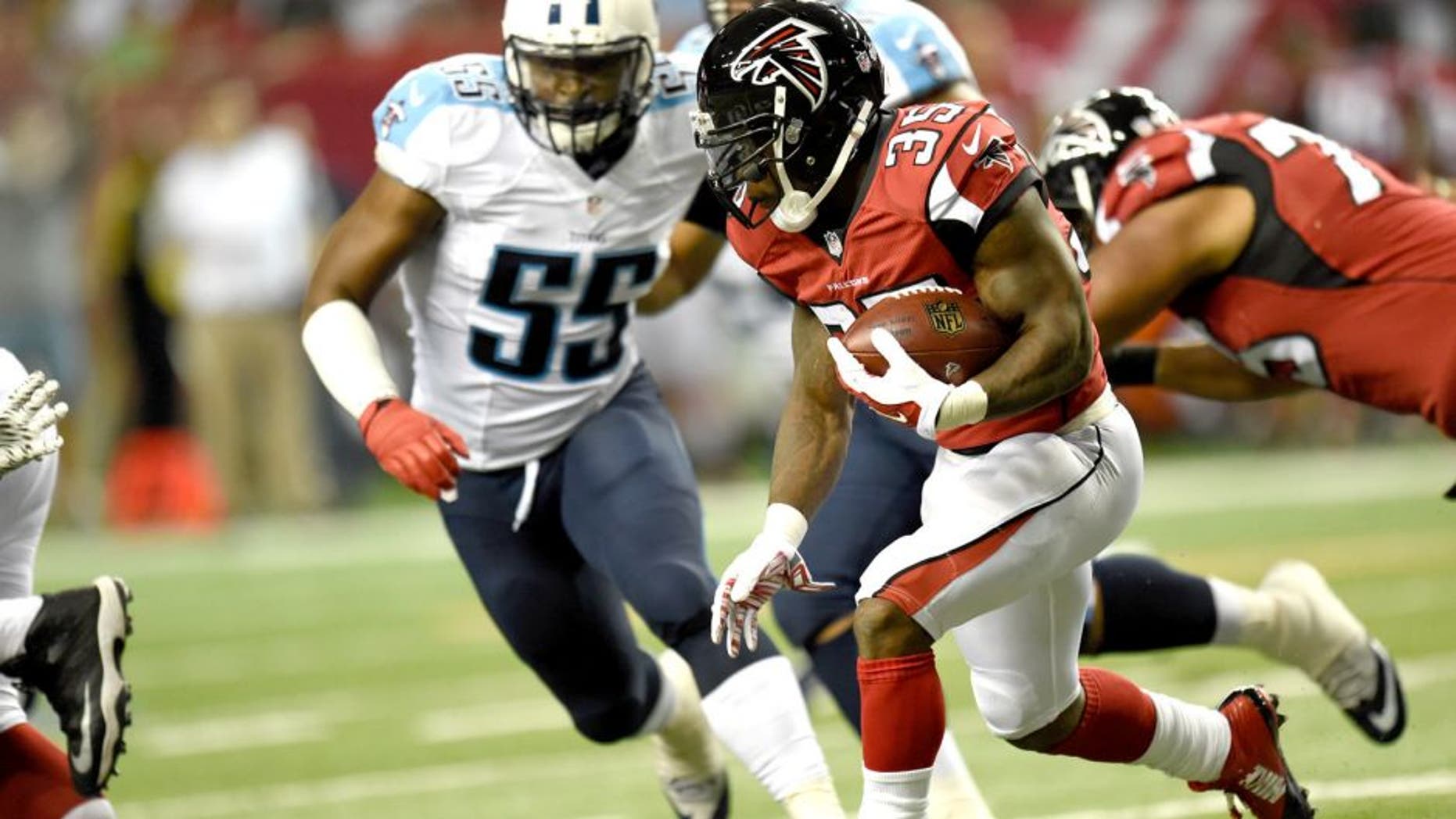 Aug 14, 2015; Atlanta, GA, USA; Atlanta Falcons running back Antone Smith (35) runs past Tennessee Titans linebacker Zach Brown (55) during the first half at the Georgia Dome. The Falcons defeated the Titans 31-24. Mandatory Credit: Dale Zanine-USA TODAY Sports