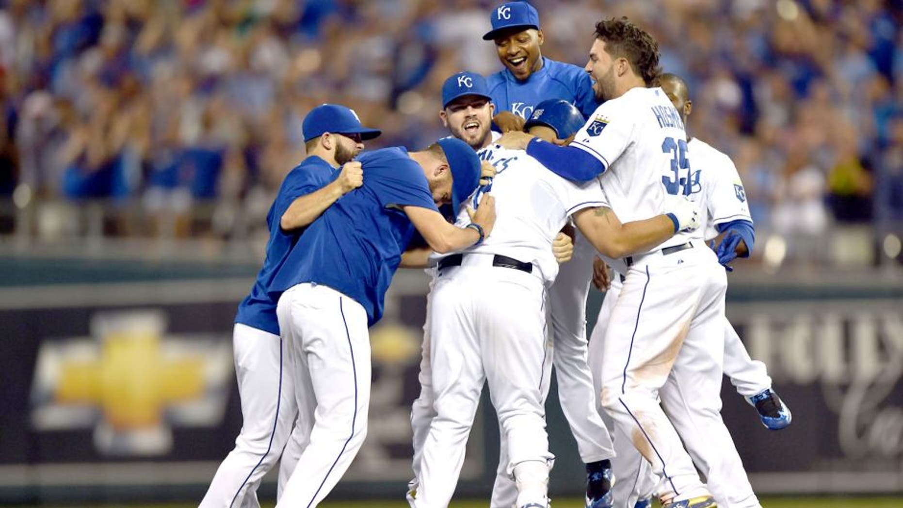 Aug 16, 2015; Kansas City, MO, USA; Kansas City Royals players celebrate after Kendrys Morales (center) hit a walk off single against the Los Angeles Angels during the tenth inning at Kauffman Stadium. Mandatory Credit: Peter G. Aiken-USA TODAY Sports