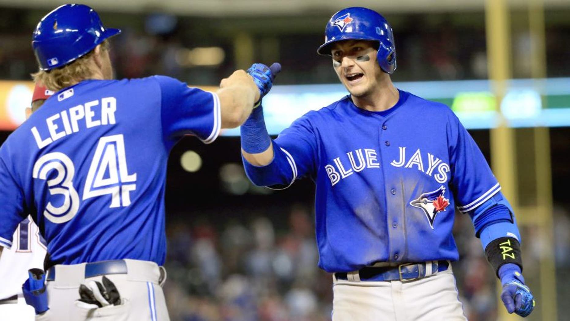 Aug 25, 2015; Arlington, TX, USA; Toronto Blue Jays shortstop Troy Tulowitzki (2) celebrates with first base coach Tim Leiper (34) after hitting the game tying single against the Texas Rangers during the ninth inning at Globe Life Park in Arlington. Mandatory Credit: Kevin Jairaj-USA TODAY Sports